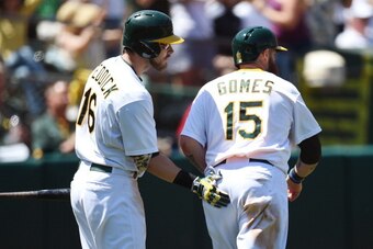 OAKLAND, CA - AUGUST 02:  Jonny Gomes #15 of the Oakland Athletics is congratulated by Josh Reddick #16 after Gomes scored in the bottom of the fifth inning against the Kansas City Royals at O.co Coliseum on August 2, 2014 in Oakland, California.  (Photo 