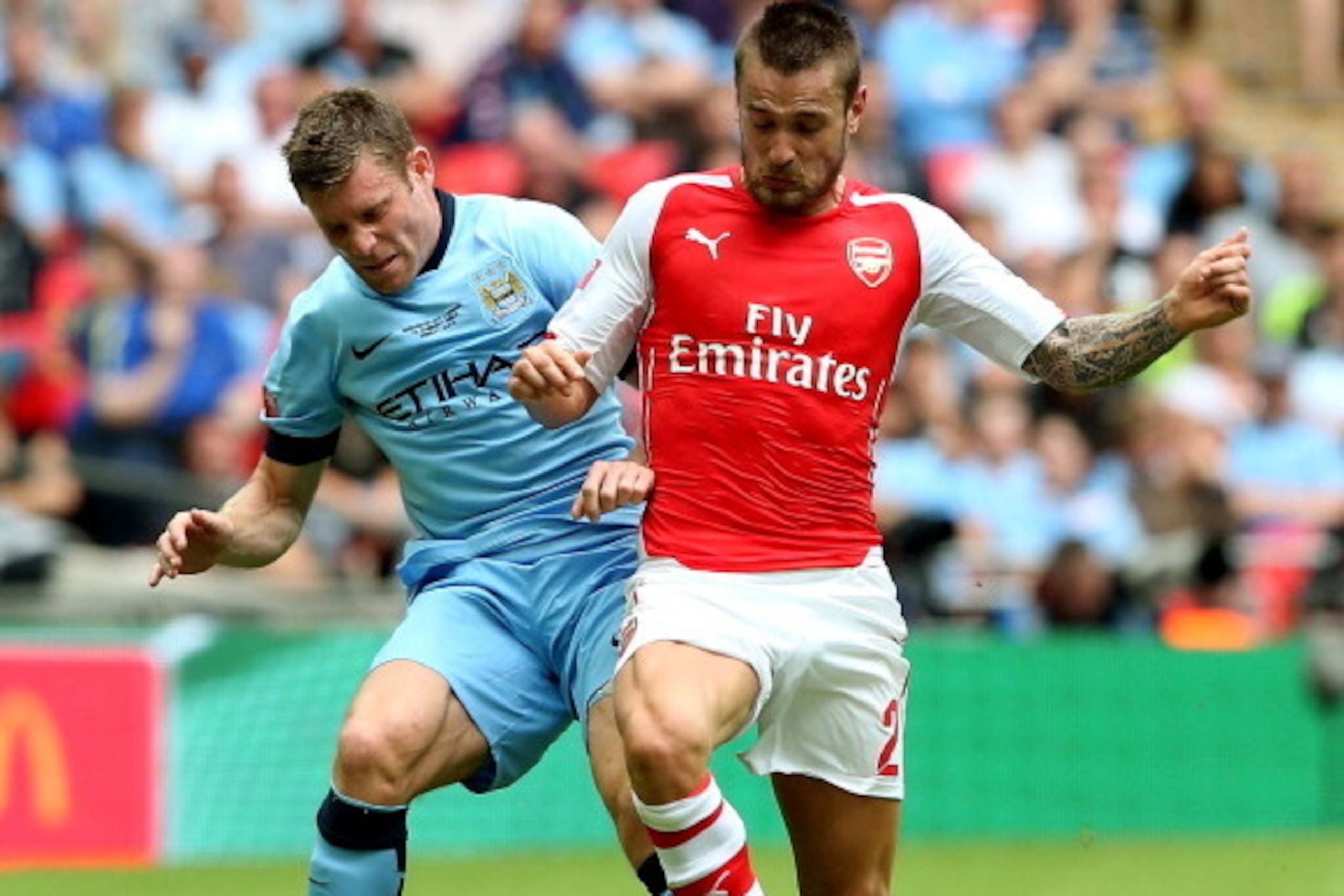 LONDON, ENGLAND - AUGUST 10:James Milner of Manchester City competes for the ball with Mathieu Debuchy of Arsenal during the FA Community Shield match between Manchester City and Arsenal at Wembley Stadium on August 10, 2014 in London, England.  (Photo by