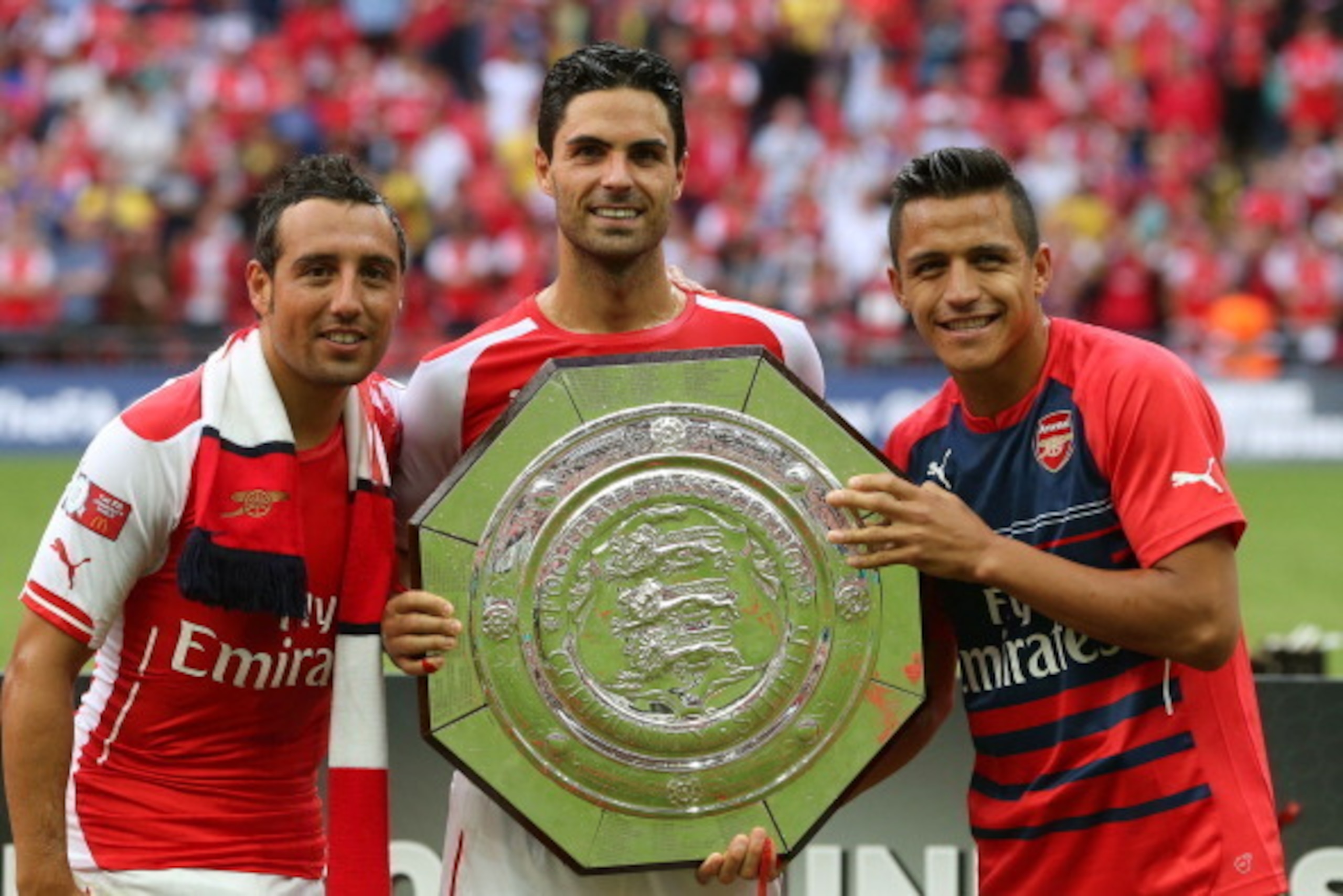 LONDON, ENGLAND - AUGUST 10:  Mikel Arteta of Arsenal holds up the trophy next to Santi Cazorla (L) and Alexis Sanchez after the FA Community Shield match between Manchester City and Arsenal at Wembley Stadium on August 10, 2014 in London, England.  (Phot