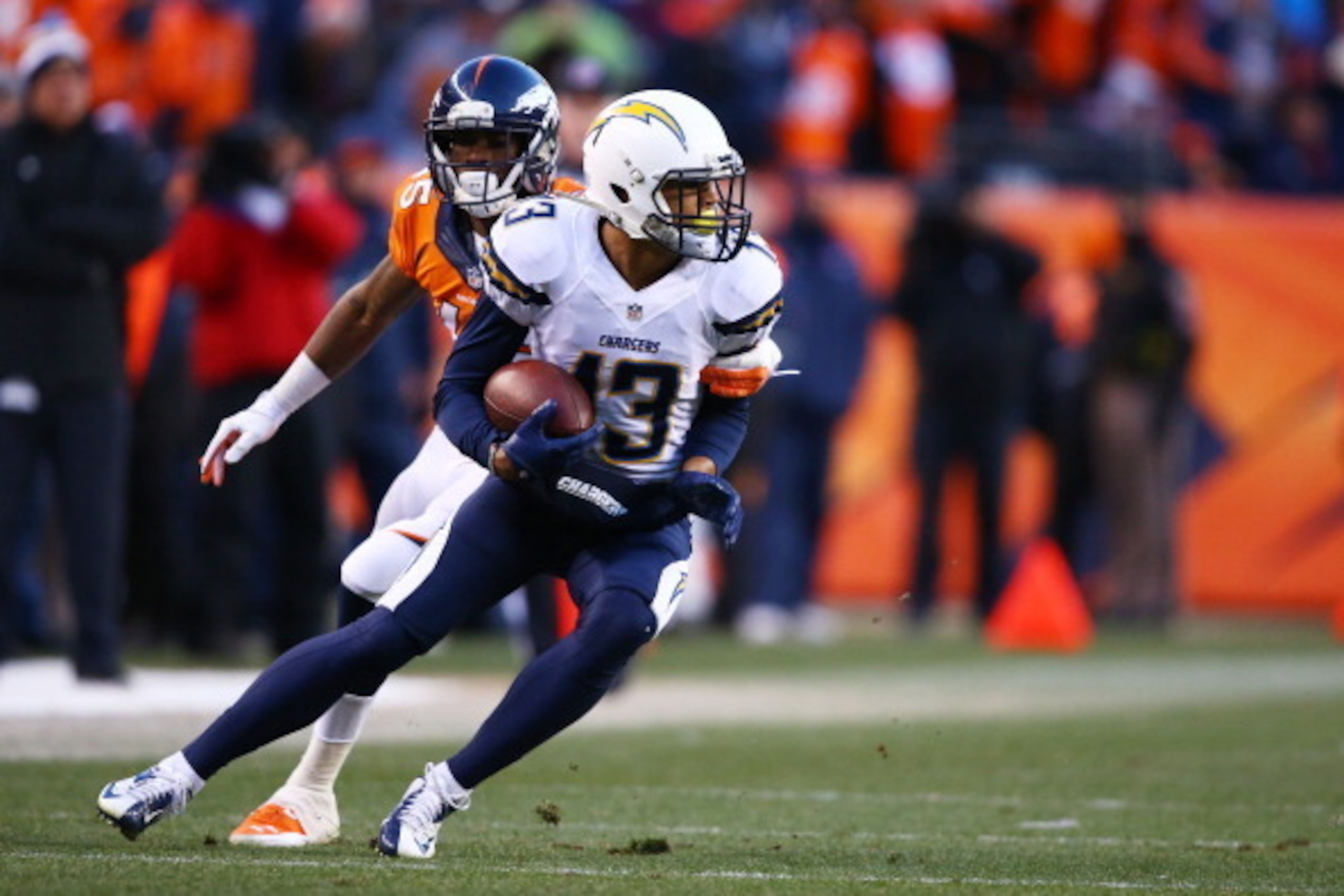 DENVER, CO - JANUARY 12:  Keenan Allen #13 of the San Diego Chargers tries to avoid the tackle of Dominique Rodgers-Cromartie #45 of the Denver Broncos during the AFC Divisional Playoff Game at Sports Authority Field at Mile High on January 12, 2014 in De