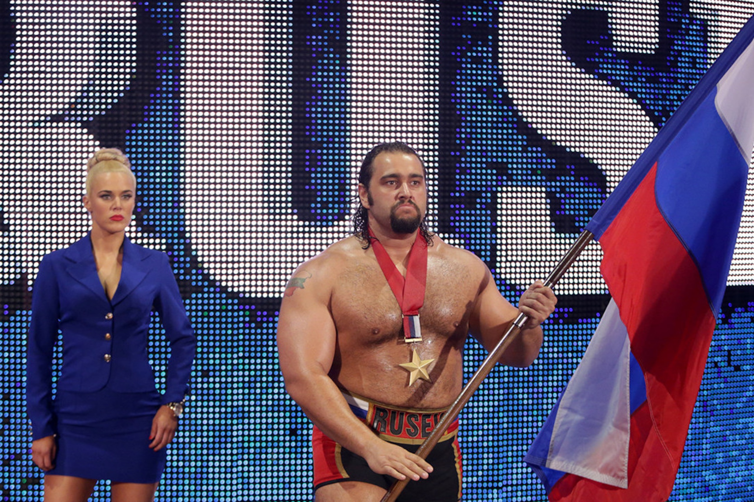 Lana stands by Rusev who proudly waves the Russian flag.