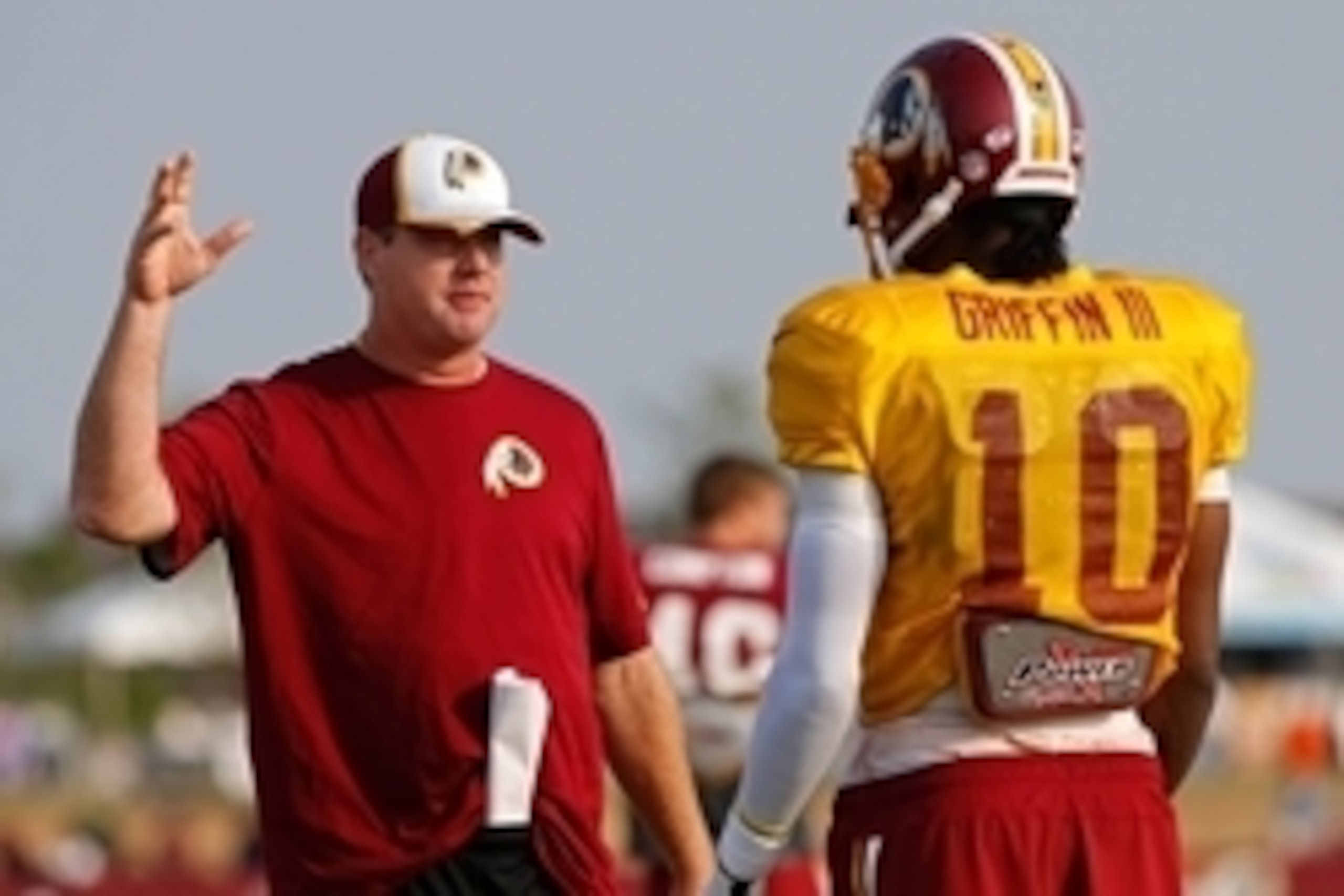 Aug 10, 2014; Richmond, VA, USA; Washington Redskins head coach Jay Gruden (L)  talks to Redskins quarterback Robert Griffin III (10) during practice on day eighteen of training camp at Bon Secours Washington Redskins Training Center. Mandatory Credit: Ge
