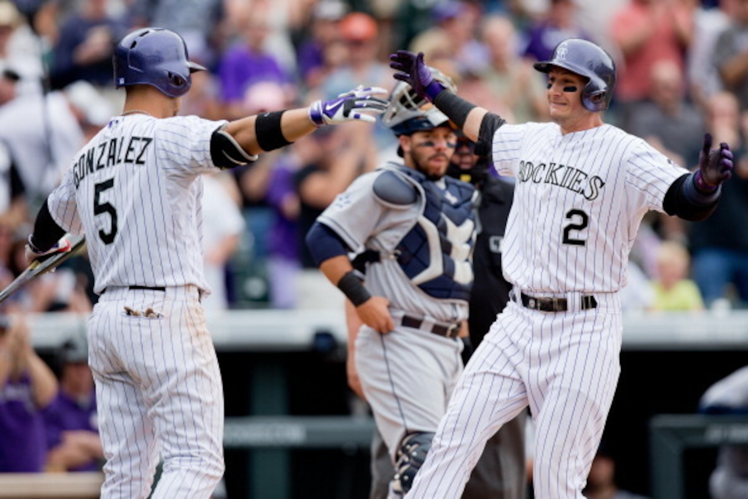 DENVER, CO - MAY 18: Troy Tulowitzki #2 of the Colorado Rockies celebrates his solo home run with Carlos Gonzalez #5 as Rene Rivera #44 of the San Diego Padres looks on during the fifth inning at Coors Field on May 18, 2014 in Denver, Colorado. The Rocki DENVER, CO - MAY 18: Troy Tulowitzki #2 of the Colorado Rockies celebrates his solo home run with Carlos Gonzalez #5 as Rene Rivera #44 of the San Diego Padres looks on during the fifth inning at Coors Field on May 18, 2014 in Denver, Colorado. The Rocki
