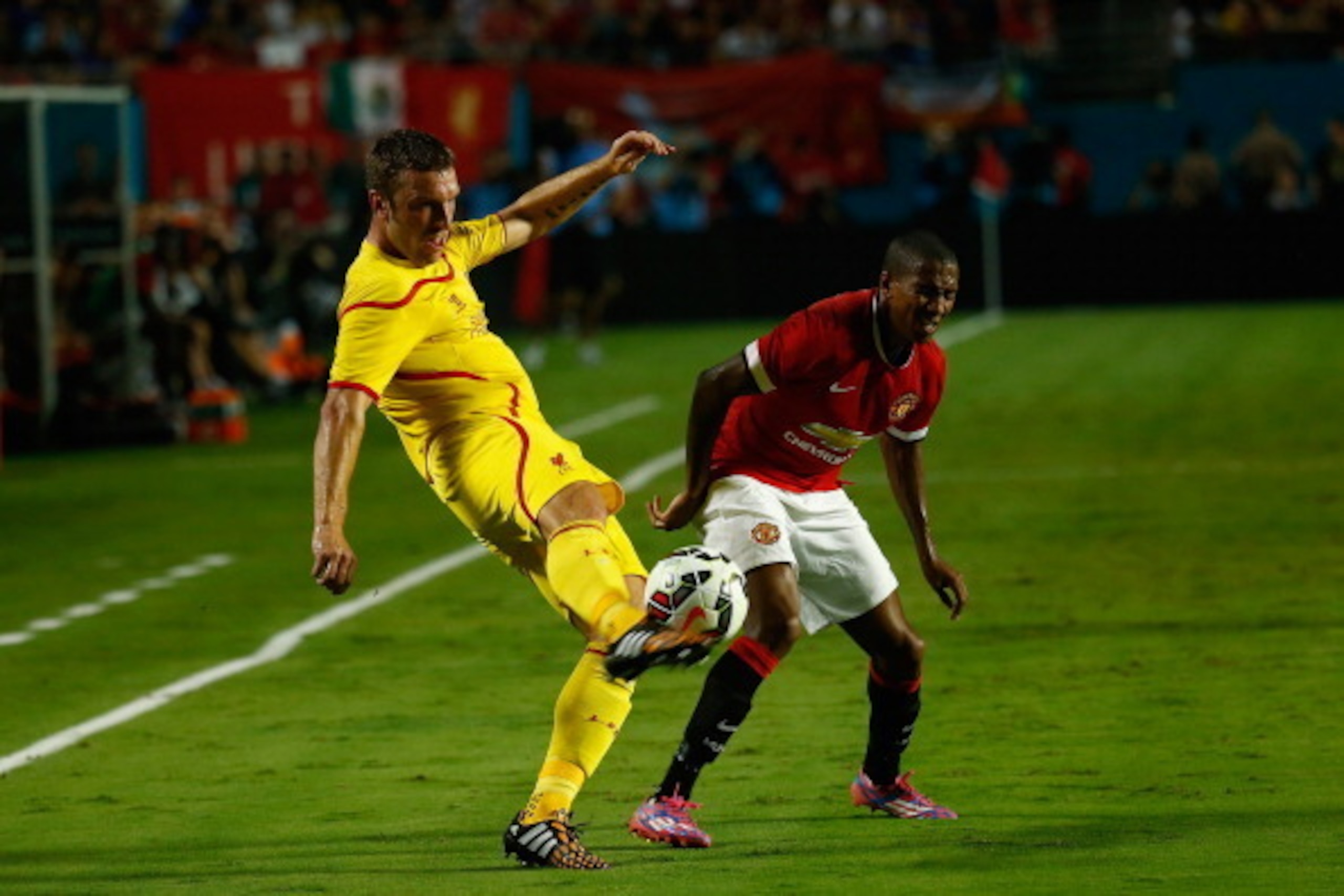 MIAMI GARDENS, FL - AUGUST 04:  Jordan Henderson #14 of Liverpool is challenged by  Ashley Young #18 of Manchester United in the Guinness International Champions Cup 2014 Final at Sun Life Stadium on August 4, 2014 in Miami Gardens, Florida.  (Photo by Ch