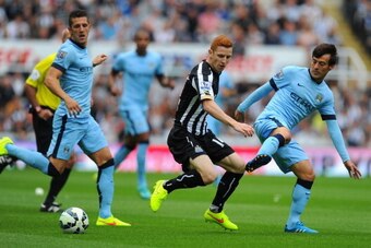 NEWCASTLE UPON TYNE, ENGLAND - AUGUST 17:  David Silva of Man City (r) is challenged by Jack Colback during the Barclays Premier League match between Newcastle United and Manchester City at St James' Park on August 17, 2014 in Newcastle upon Tyne, England