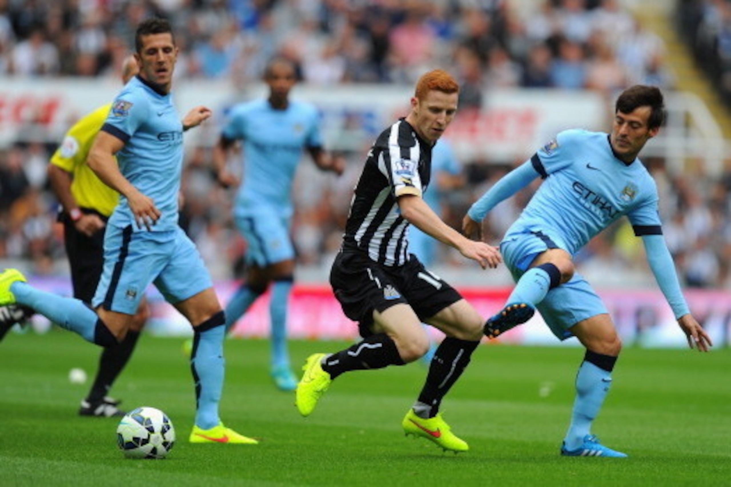 NEWCASTLE UPON TYNE, ENGLAND - AUGUST 17:  David Silva of Man City (r) is challenged by Jack Colback during the Barclays Premier League match between Newcastle United and Manchester City at St James' Park on August 17, 2014 in Newcastle upon Tyne, England
