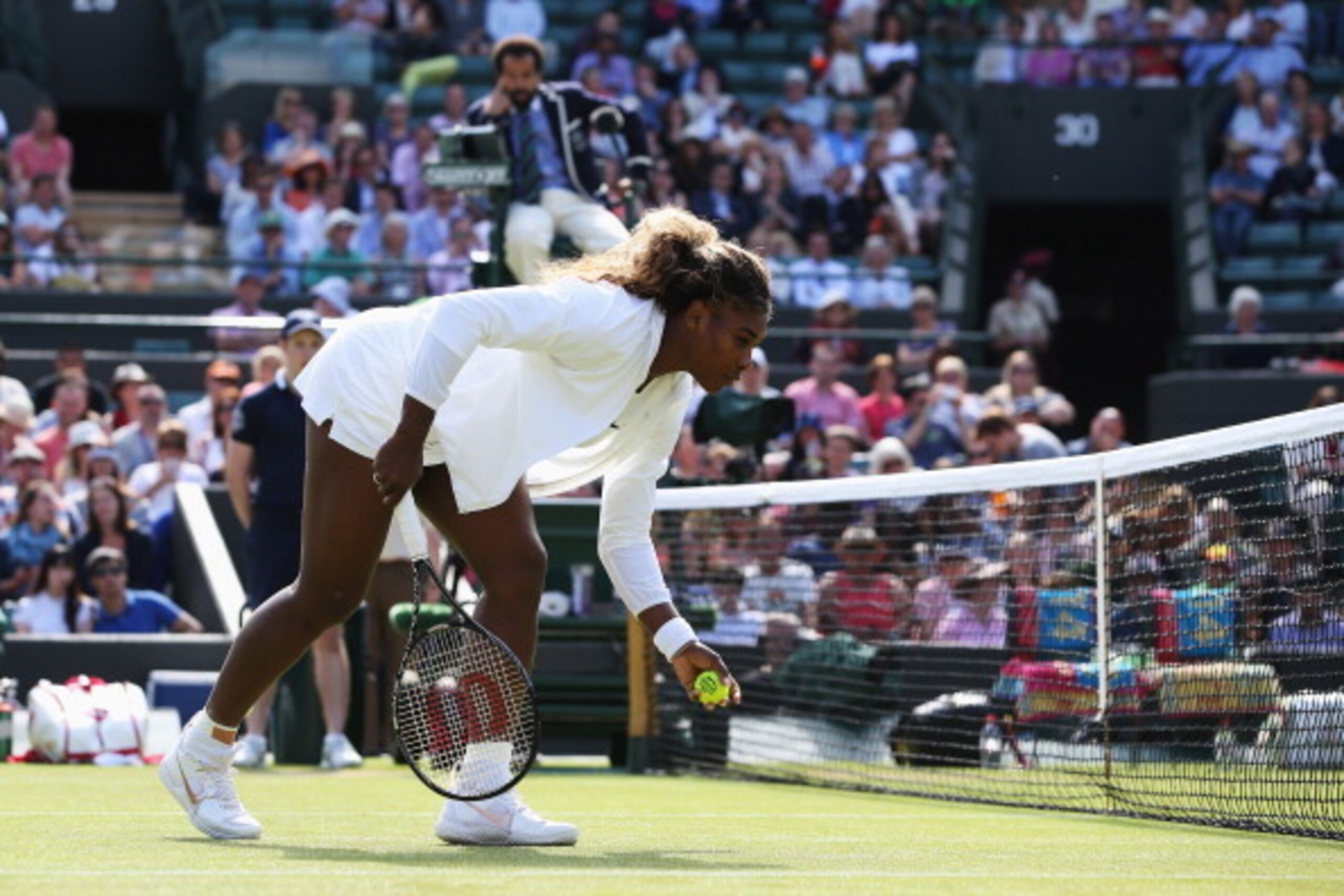 LONDON, ENGLAND - JULY 01:  Serena Williams of the United States struggles during the warm up prior her Ladies Doubles second round match with Venus against Kristina Barrois of Germany and Stefanie Voegele of Switzerland on day eight of the Wimbledon Lawn