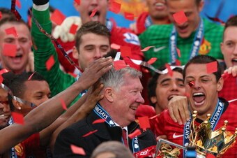 MANCHESTER, ENGLAND - MAY 12:  Manchester United Manager Sir Alex Ferguson celebrates with his players and the Premier League trophy following the Barclays Premier League match between Manchester United and Swansea City at Old Trafford on May 12, 2013 in 