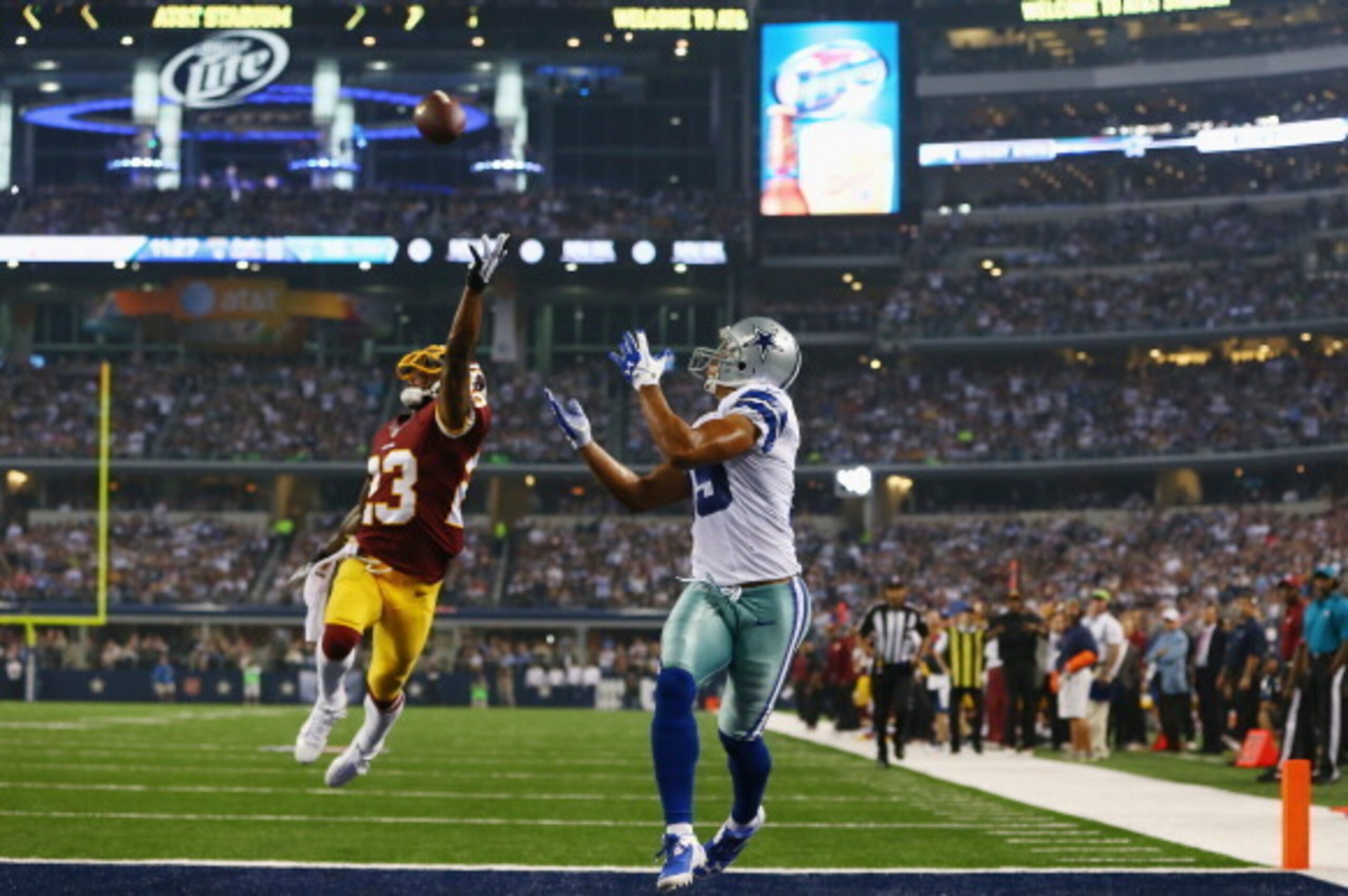 ARLINGTON, TX - OCTOBER 13:  Miles Austin #19 of the Dallas Cowboys tries to catch a pass in the end zone against  DeAngelo Hall #23 of the Washington Redskins at AT&T Stadium on October 13, 2013 in Arlington, Texas.  (Photo by Tom Pennington/Getty Images
