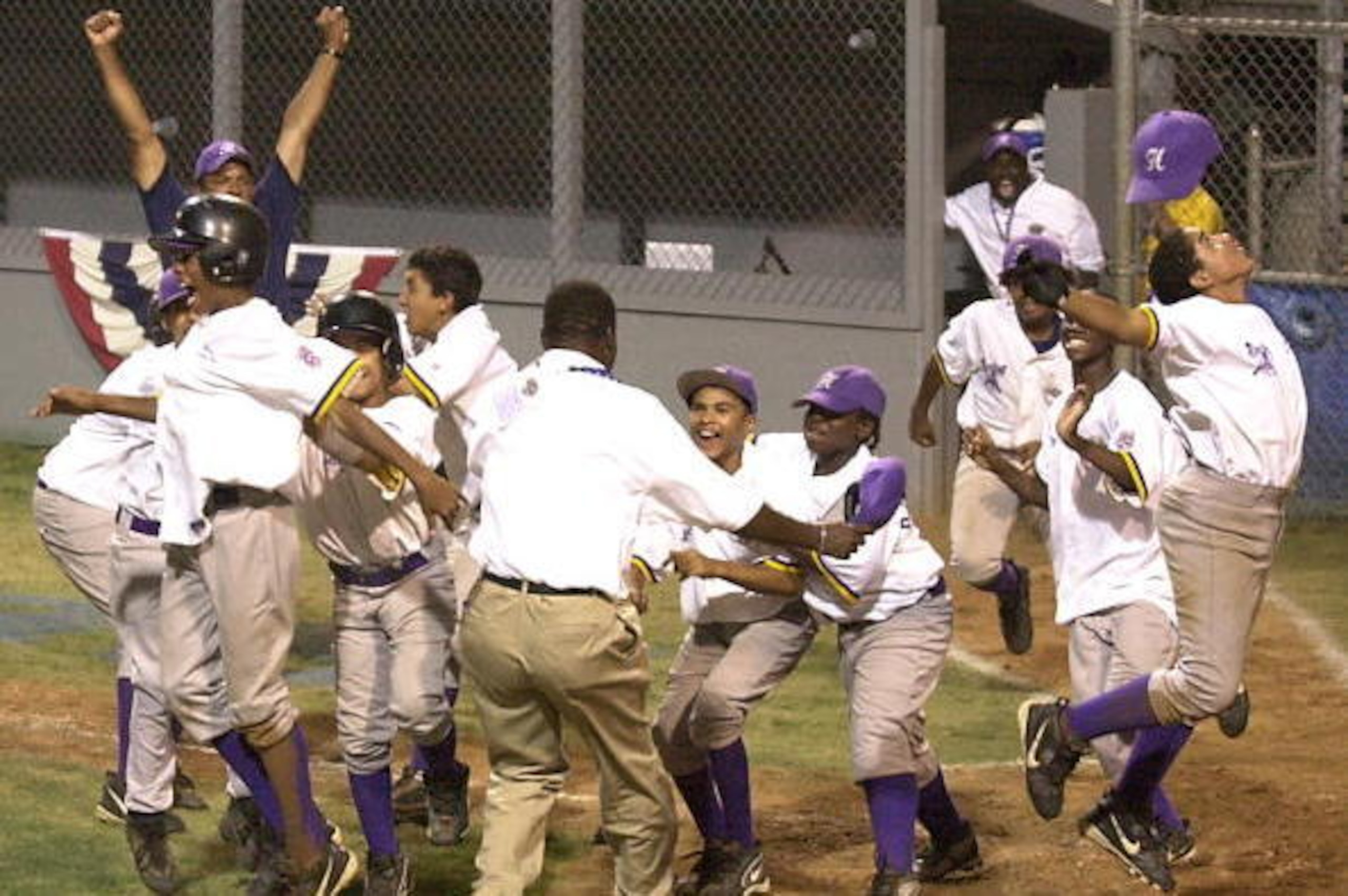 BRISTOL, CT - AUGUST 13:  The Harlem, New York Little League goes wild after scoring the winning run on a wild pitch during the 7th inning of an extra inning game of the Mid-Atlantic Championship in Bristol, CT on August 13, 2002. Harlem defeated the Penn