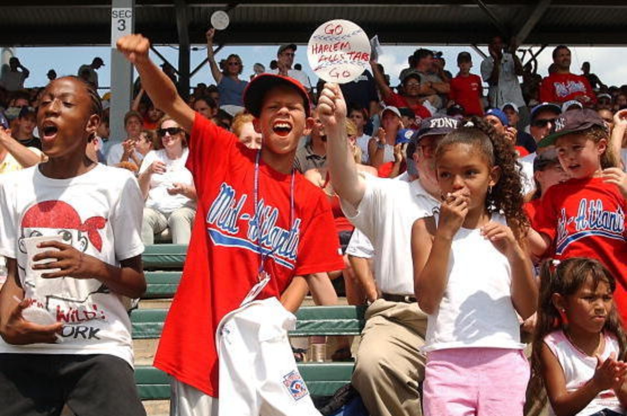 WILLIAMSPORT, PA - AUGUST 17:  Alan James (C) cheers for the Harlem Little League during their game against the Southeast champion Forsyth team at Lamade Stadium at the Little League World Series August 17, 2002 in Williamsport, Pennsylvania. Harlem defea