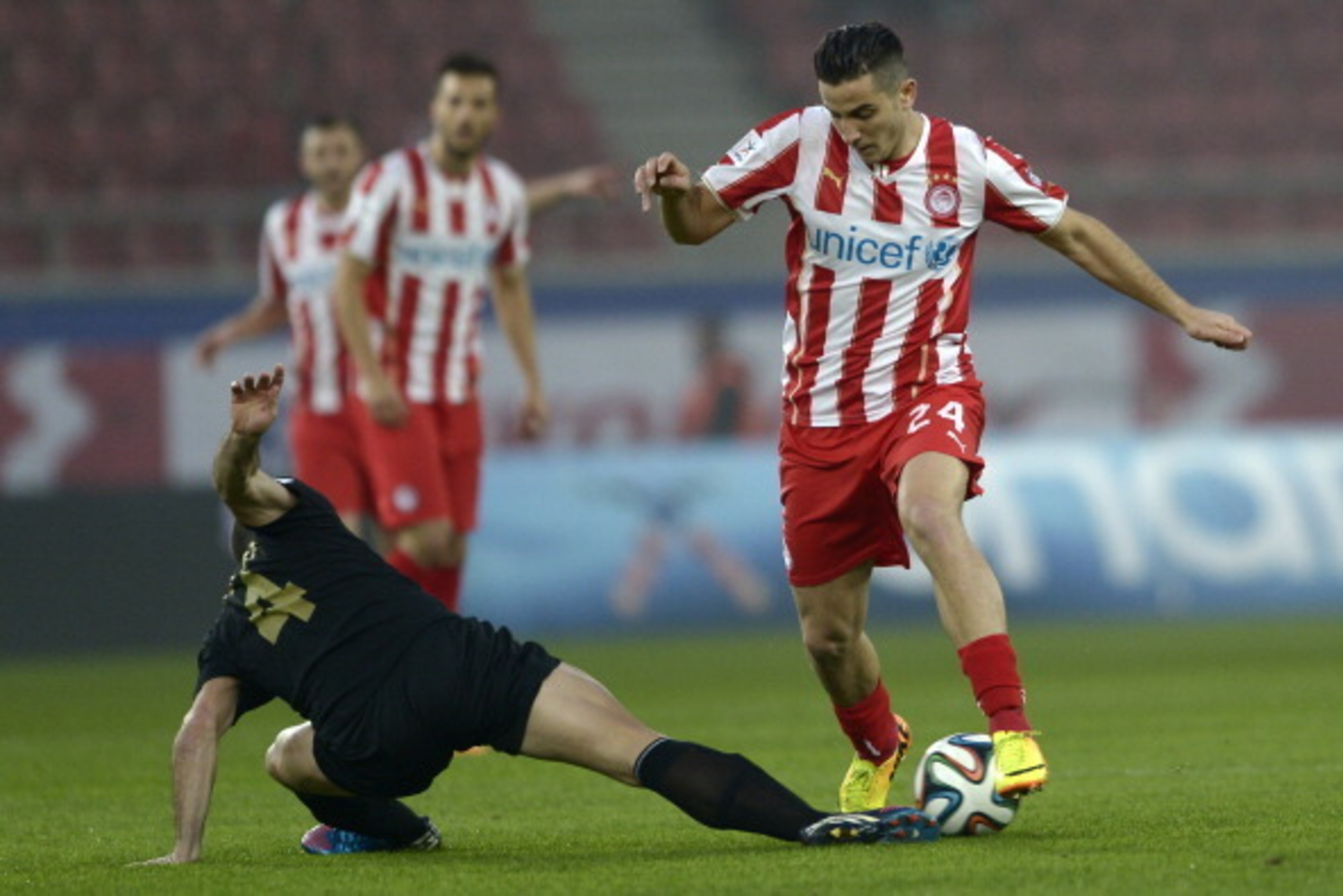ATHENS,GREECE - JANUARY 18:  Kostas Manolas of Olympiacos dribbles past Pedro Sass Petrazzi of Levadiakos with the ball during the Greek Superleague match between Olympiacos and  Levadiakos at the Georgios Karaiskakis Stadium on January 18, 2014 in Athens