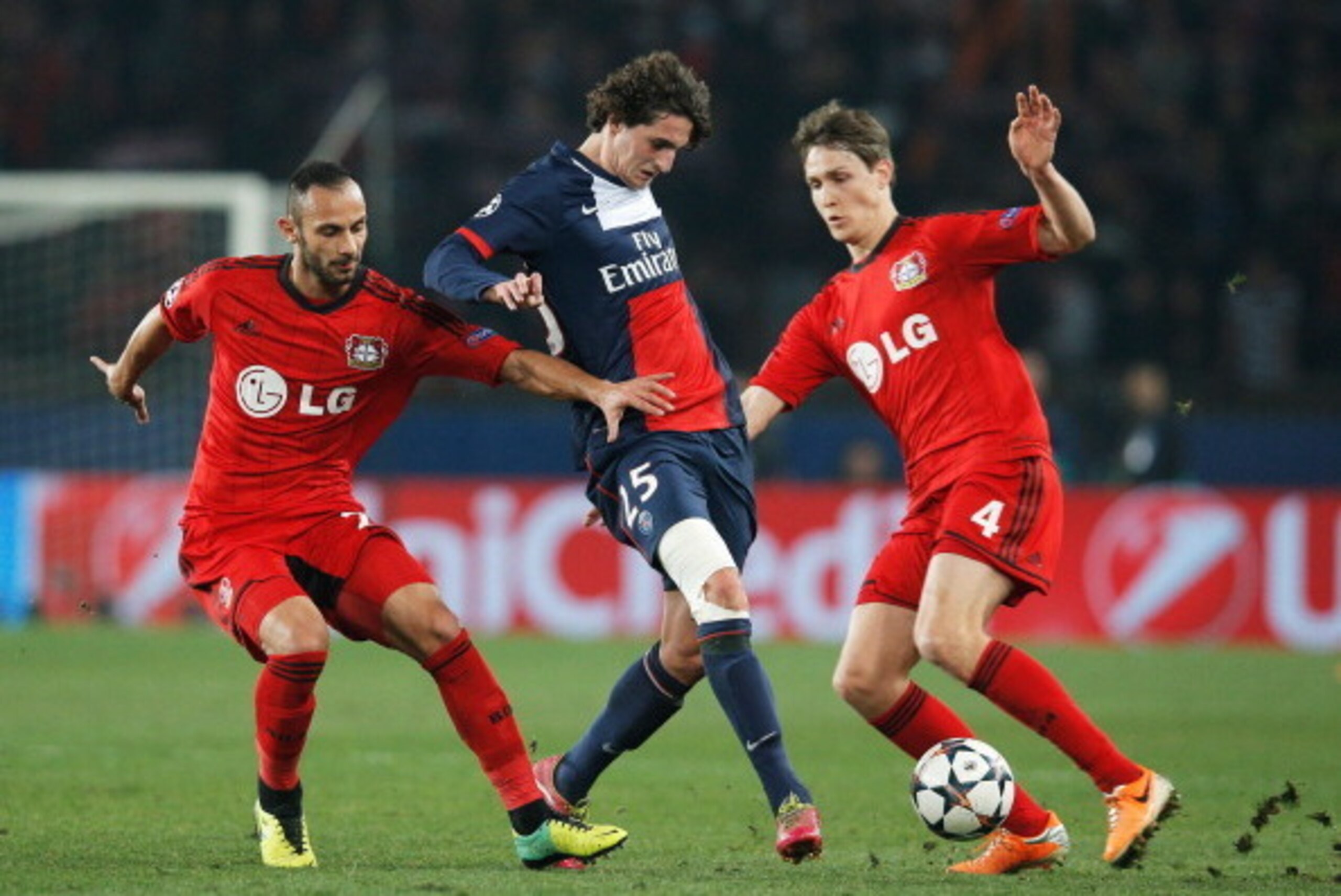 PARIS, FRANCE - MARCH 12:  Adrien Rabiot of Paris Saint-Germain (C) battles with Omer Toprak (L) and Philipp Wollscheid of Bayer Leverkusen (R) during the UEFA Champions League Round of 16 second leg match between Paris Saint-Germain FC and Bayer Leverkus