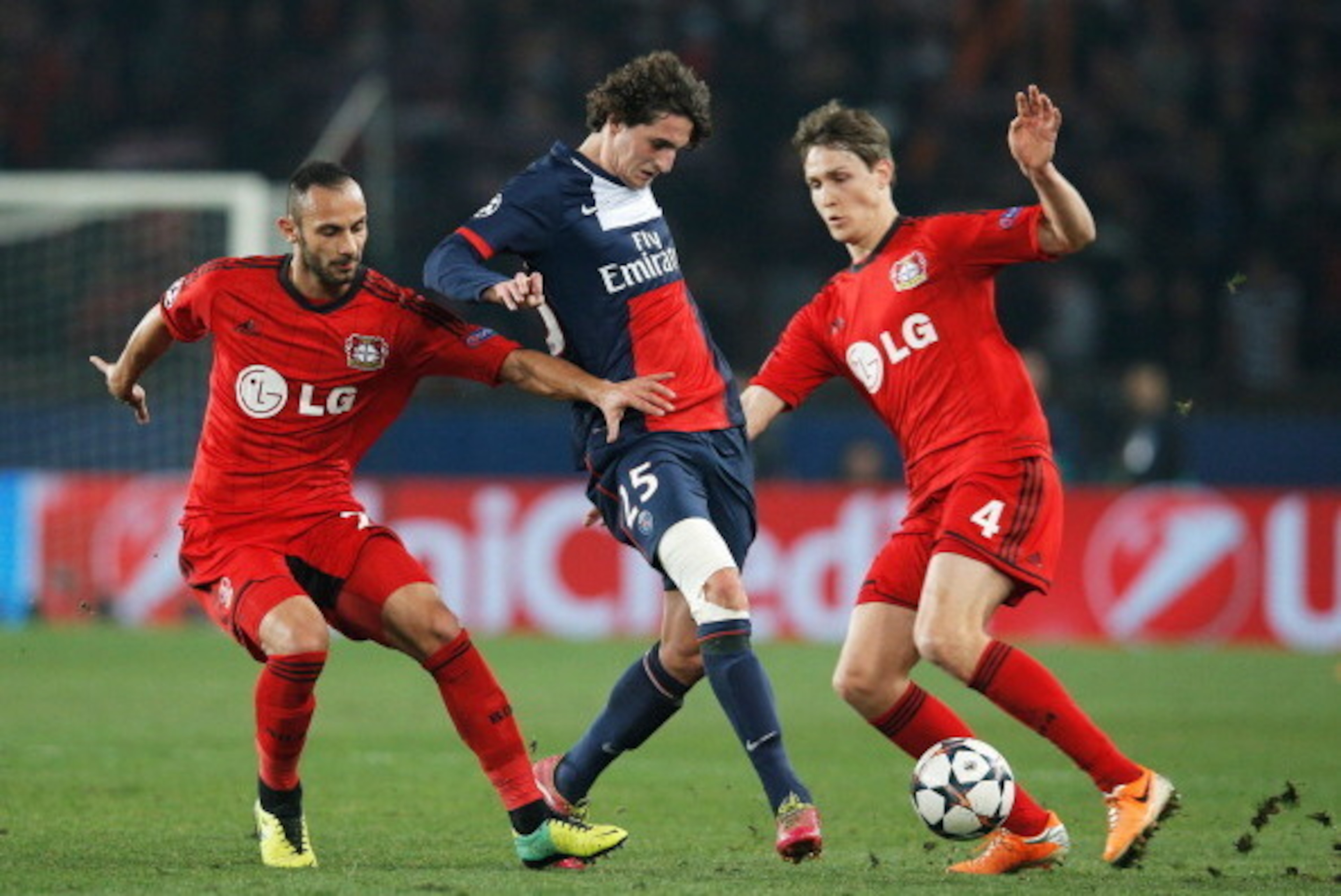 PARIS, FRANCE - MARCH 12:  Adrien Rabiot of Paris Saint-Germain (C) battles with Omer Toprak (L) and Philipp Wollscheid of Bayer Leverkusen (R) during the UEFA Champions League Round of 16 second leg match between Paris Saint-Germain FC and Bayer Leverkus