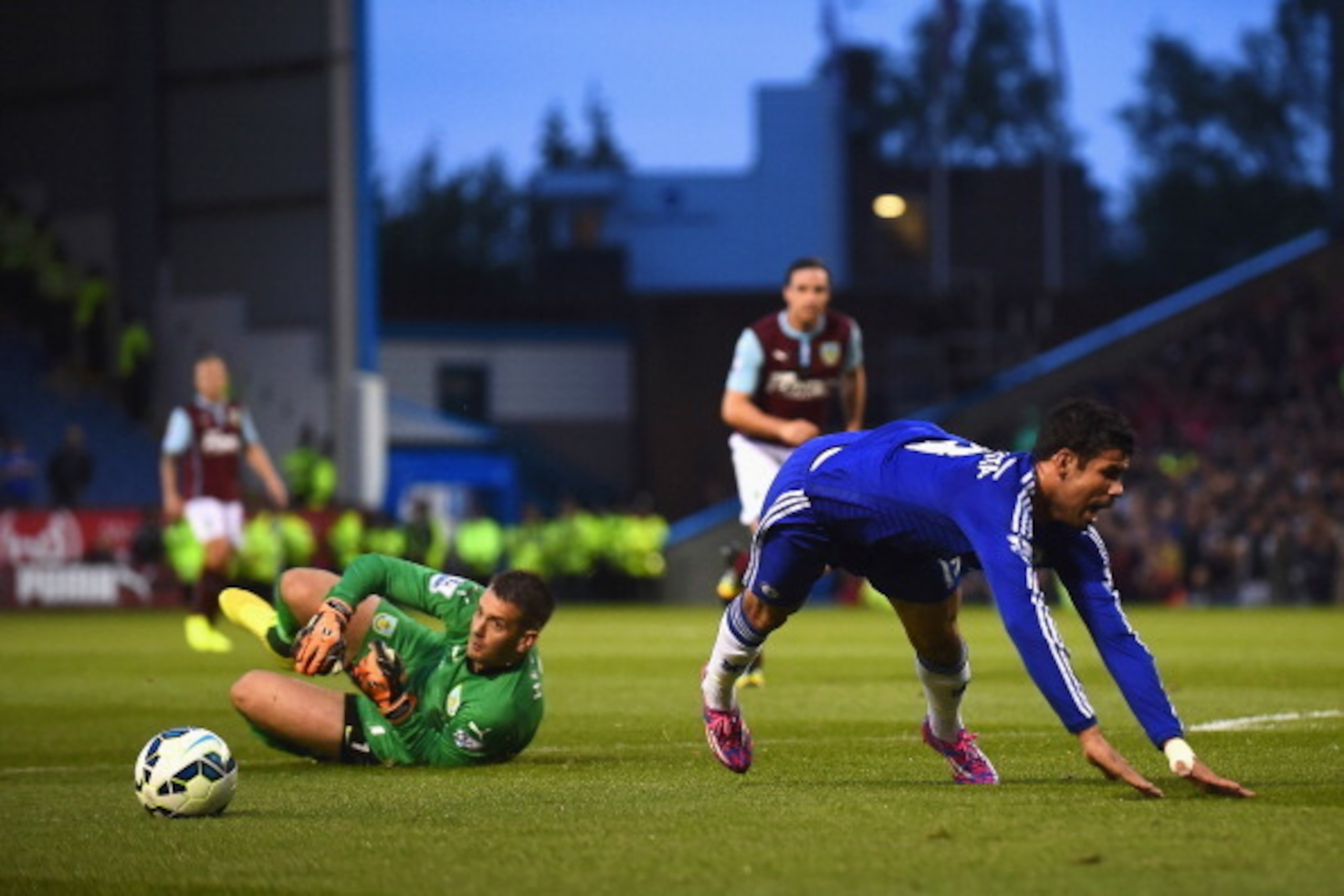 BURNLEY, ENGLAND - AUGUST 18:  Diego Costa of Chelsea goes to ground after a challenge from Thomas Heaton of Burnley during the Barclays Premier League match between Burnley and Chelsea at Turf Moor on August 18, 2014 in Burnley, England.  (Photo by Laure