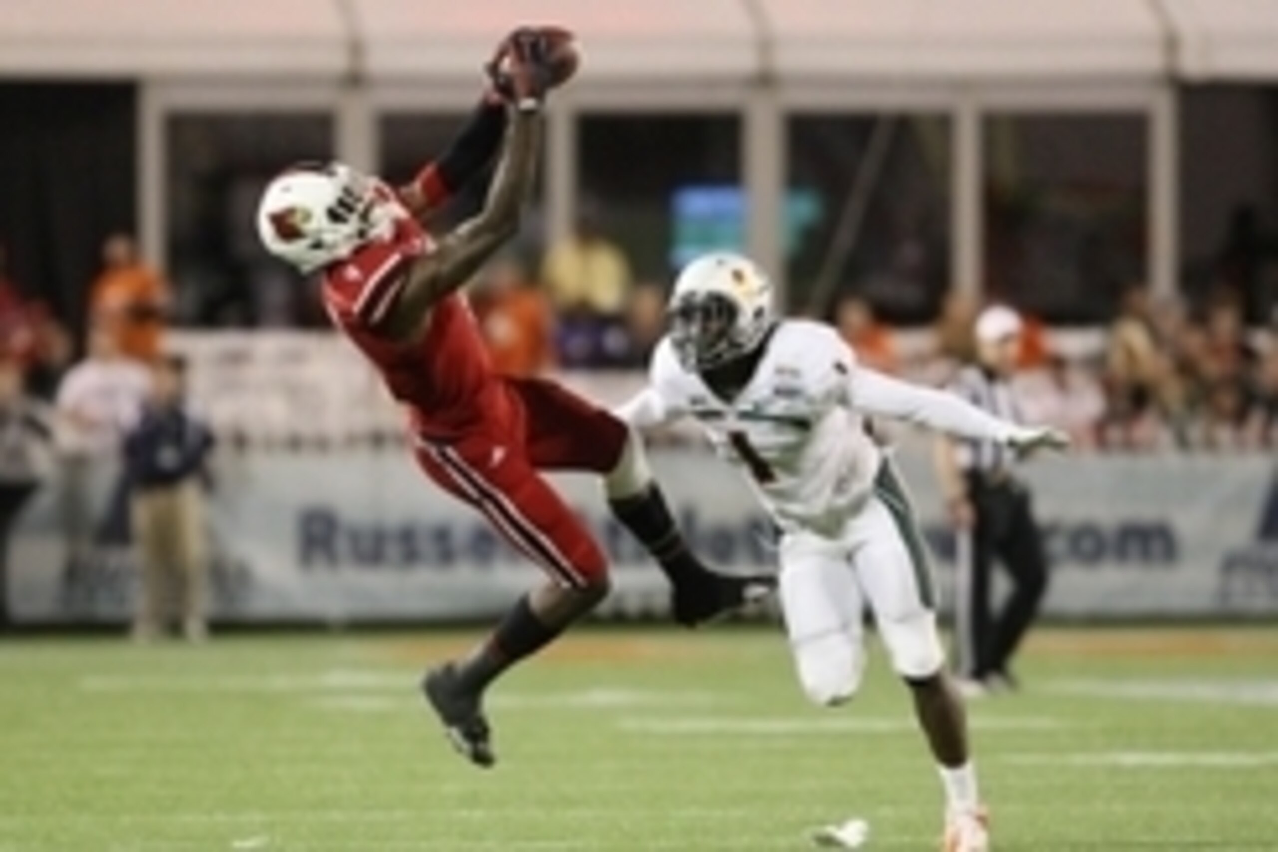 Dec 28, 2013; Orlando, FL, USA; Louisville Cardinals wide receiver DeVante Parker (9) catches a pass while defended by Miami Hurricanes defensive back Artie Burns (1) during the second half of the Russell Athletic Bowl at Florida Citrus Bowl Stadium. Mand