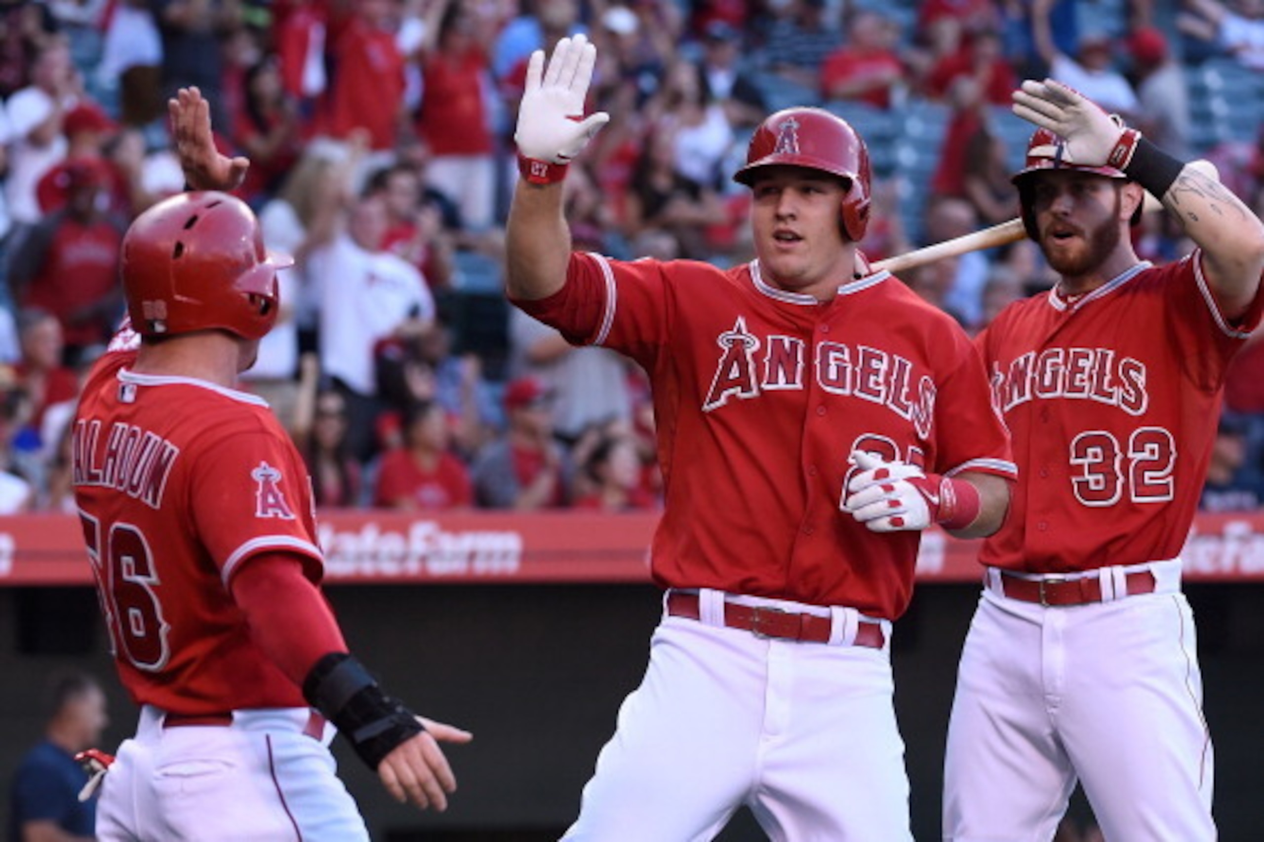 ANAHEIM, CA - AUGUST 09:  (L-R) Kole Calhoun #56 and Mike Trout #27 of the Los Angeles Angels of Anaheim score in the first inning against the Boston Red Sox as Josh Hamilton #32 looks on at Angel Stadium of Anaheim on August 9, 2014 in Anaheim, Californi