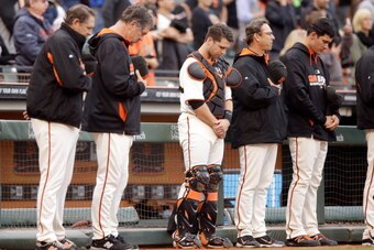 SAN FRANCISCO, CA - AUGUST 12: (L-R)  Members of the San Francisco Giants pitching coach Dave Righetti, manager Bruce Bochy, Buster Posey #28, bench coach Ron Wotus, and Javier Lopez #49 stand for a moment of silence for the death of actor Robin Williams 