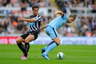 NEWCASTLE UPON TYNE, ENGLAND - AUGUST 17:  Edin Dzeko of Man City (r) is challenged by Daryl Janmaat during the Barclays Premier League match between Newcastle United and Manchester City at St James' Park on August 17, 2014 in Newcastle upon Tyne, England