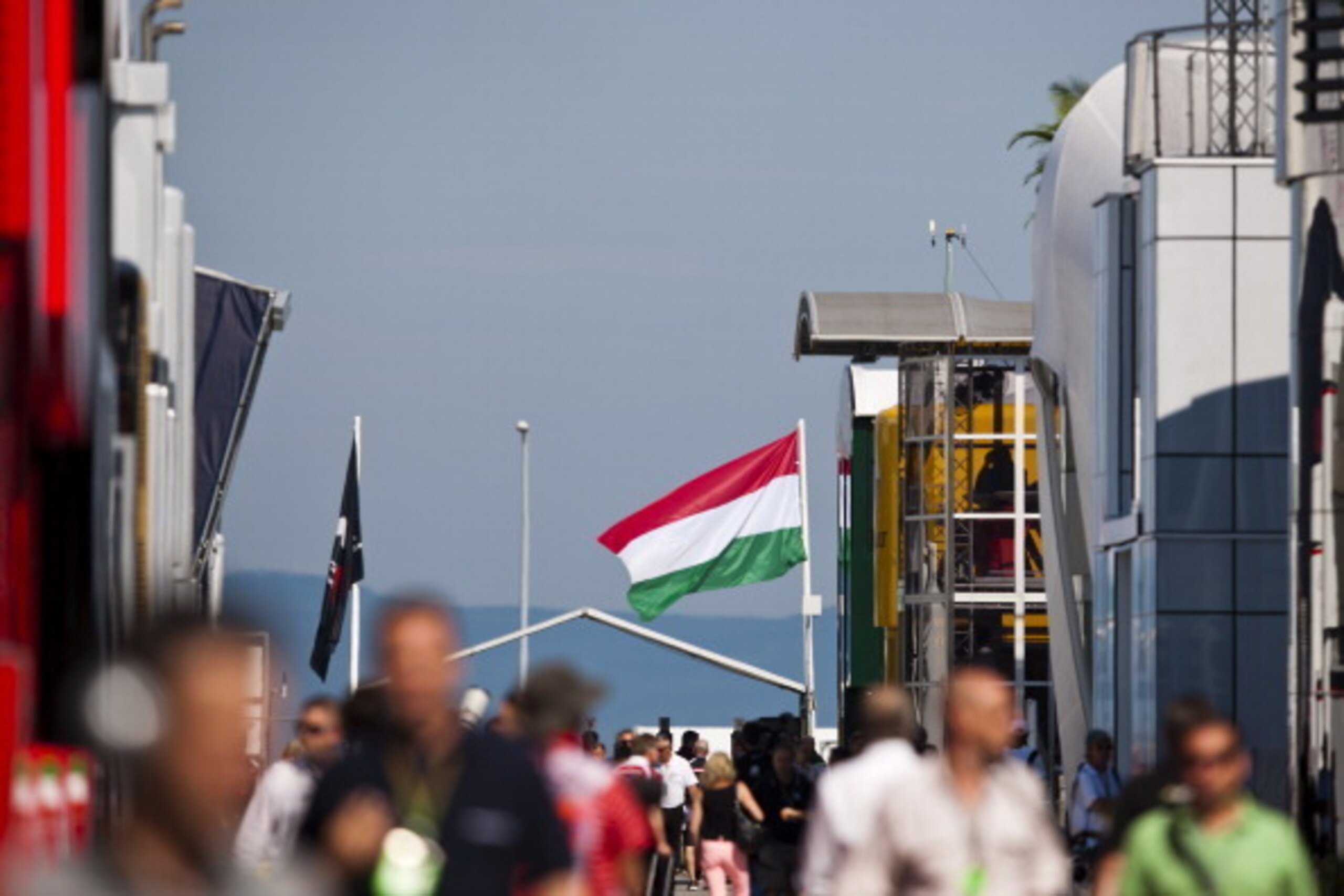 BUDAPEST, HUNGARY - JULY 25:  A Hungarian national flag flaps in the wind as people walk through the paddock during practice ahead of the Hungarian Formula One Grand Prix at Hungaroring on July 25, 2014 in Budapest, Hungary.  (Photo by Drew Gibson/Getty I