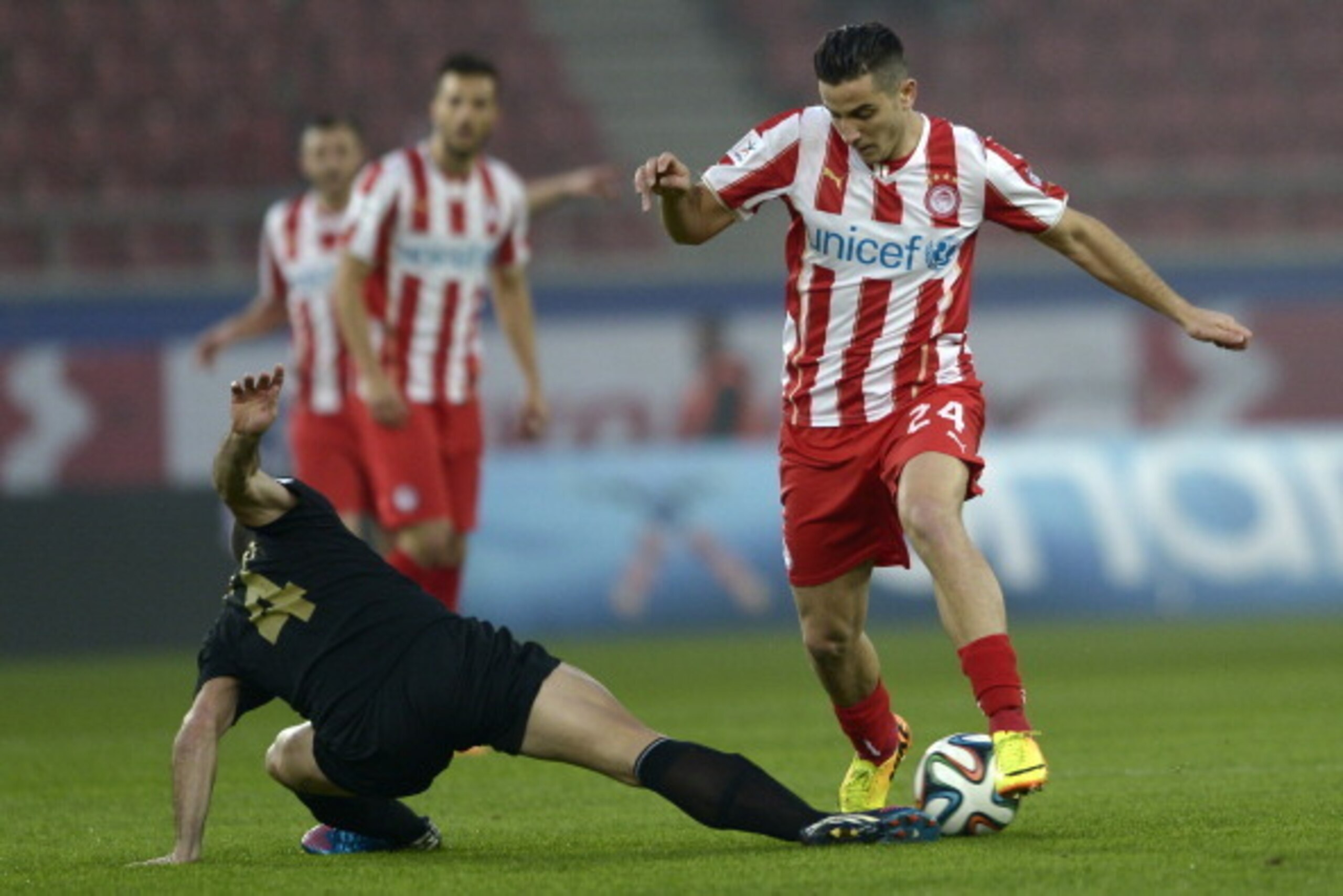 ATHENS,GREECE - JANUARY 18:  Kostas Manolas of Olympiacos dribbles past Pedro Sass Petrazzi of Levadiakos with the ball during the Greek Superleague match between Olympiacos and  Levadiakos at the Georgios Karaiskakis Stadium on January 18, 2014 in Athens