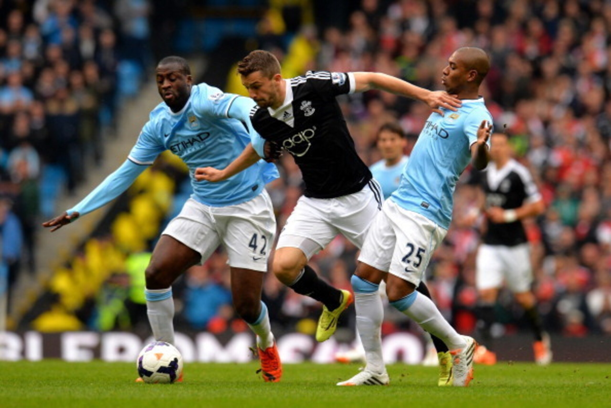 MANCHESTER, ENGLAND - APRIL 05:  Jay Rodriguez of Southampton is challenged by Yaya Toure (L) and Fernandinho (R) of Manchester City during the Barclays Premier League match between Manchester City and Southampton at Etihad Stadium on April 5, 2014 in Man