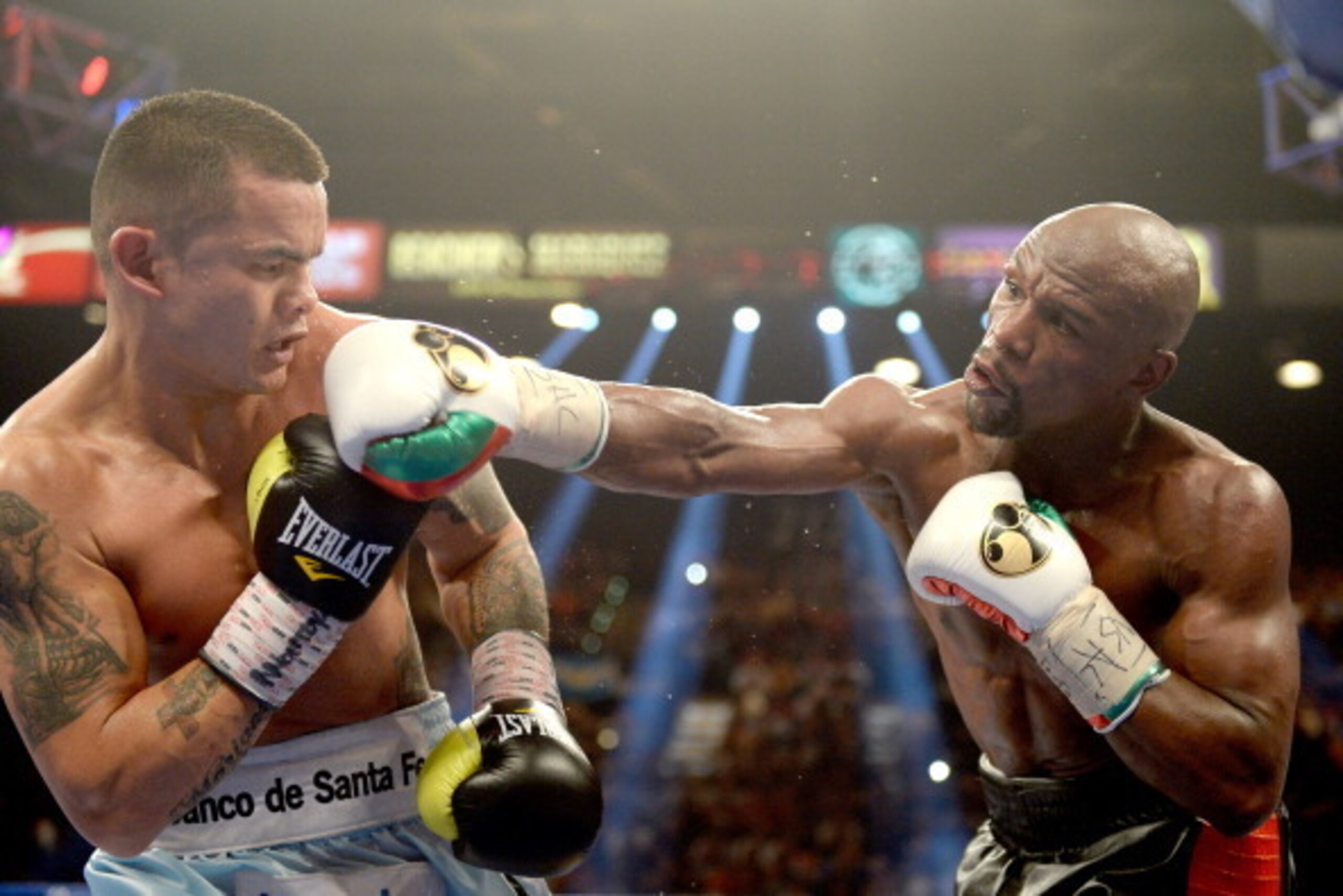 LAS VEGAS, NV - MAY 03:  (R-L) Floyd Mayweather Jr. knocks back Marcos Maidana during their WBC/WBA welterweight unification fight at the MGM Grand Garden Arena on May 3, 2014 in Las Vegas, Nevada. Mayweather took Maidana's title with a majority-decision 