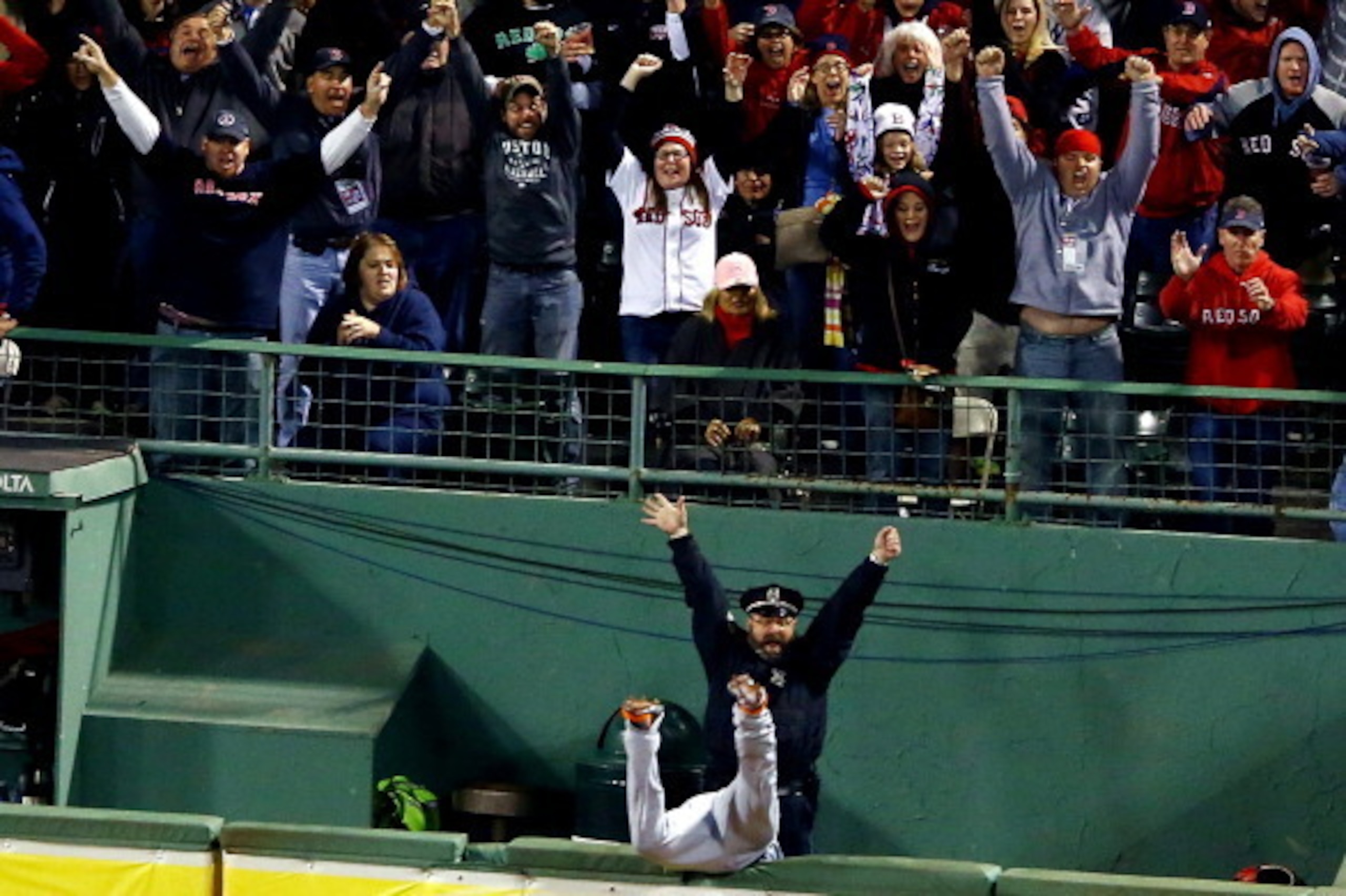 BOSTON, MA - OCTOBER 13: Boston police officer Steve Horgan reacts as Torii Hunter #48 of the Detroit Tigers tries to catch a grand slam hit by David Ortiz #34 of the Boston Red Sox in the eighth inning of Game Two of the American League Championship Seri