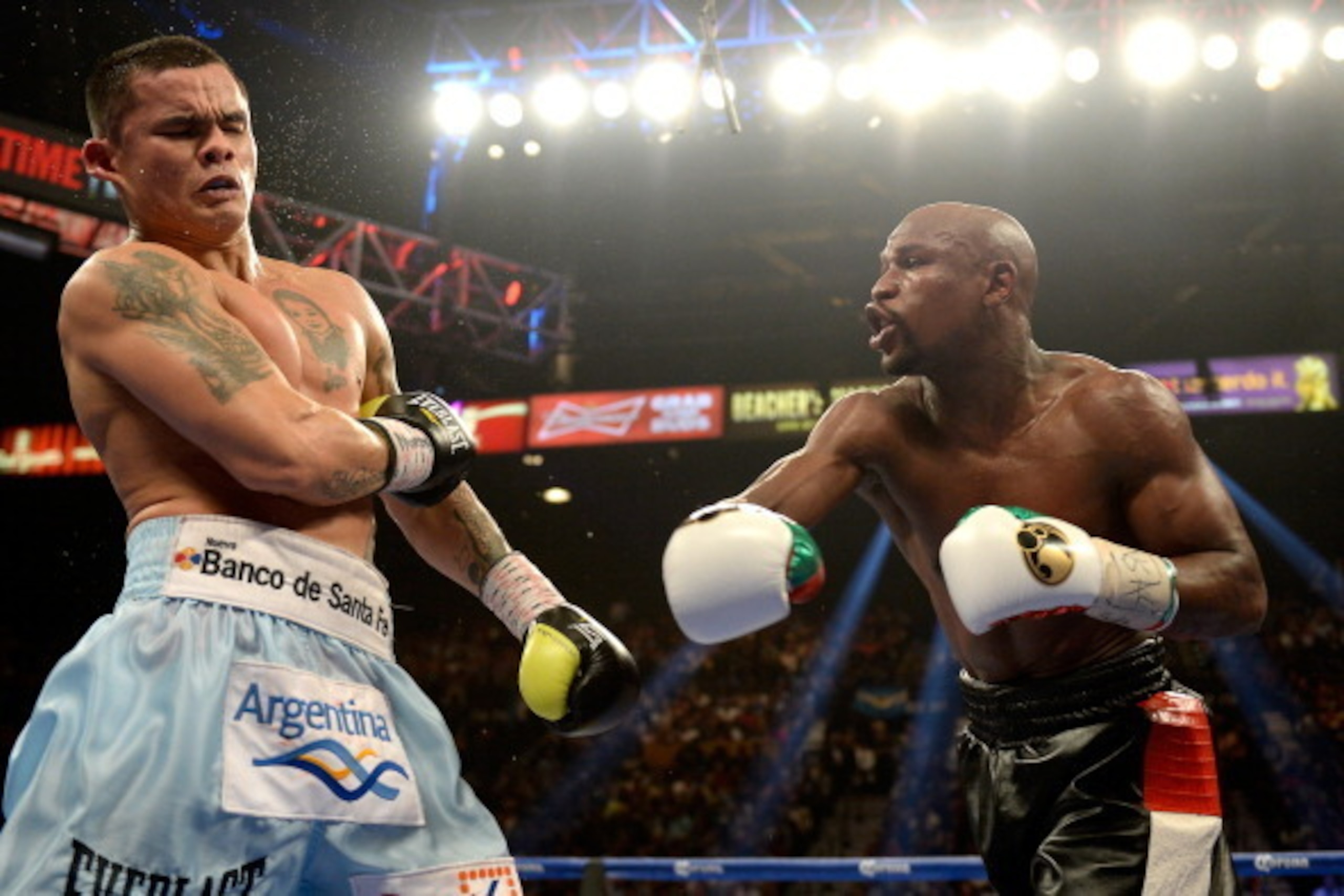 LAS VEGAS, NV - MAY 03:  (R-L) Floyd Mayweather Jr. knocks back Marcos Maidana during their WBC/WBA welterweight unification fight at the MGM Grand Garden Arena on May 3, 2014 in Las Vegas, Nevada. Mayweather took Maidana's title with a majority-decision 