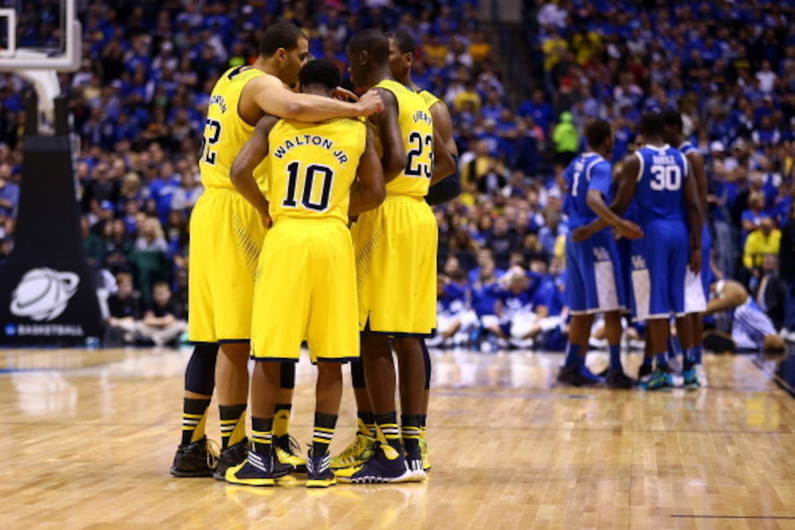 INDIANAPOLIS, IN - MARCH 30: Jordan Morgan #52, Derrick Walton Jr. #10 and Caris LeVert #23 of the Michigan Wolverines huddle with their team before their midwest regional final against the Kentucky Wildcats part of the 2014 NCAA Men's Basketball Tournam INDIANAPOLIS, IN - MARCH 30: Jordan Morgan #52, Derrick Walton Jr. #10 and Caris LeVert #23 of the Michigan Wolverines huddle with their team before their midwest regional final against the Kentucky Wildcats part of the 2014 NCAA Men's Basketball Tournam