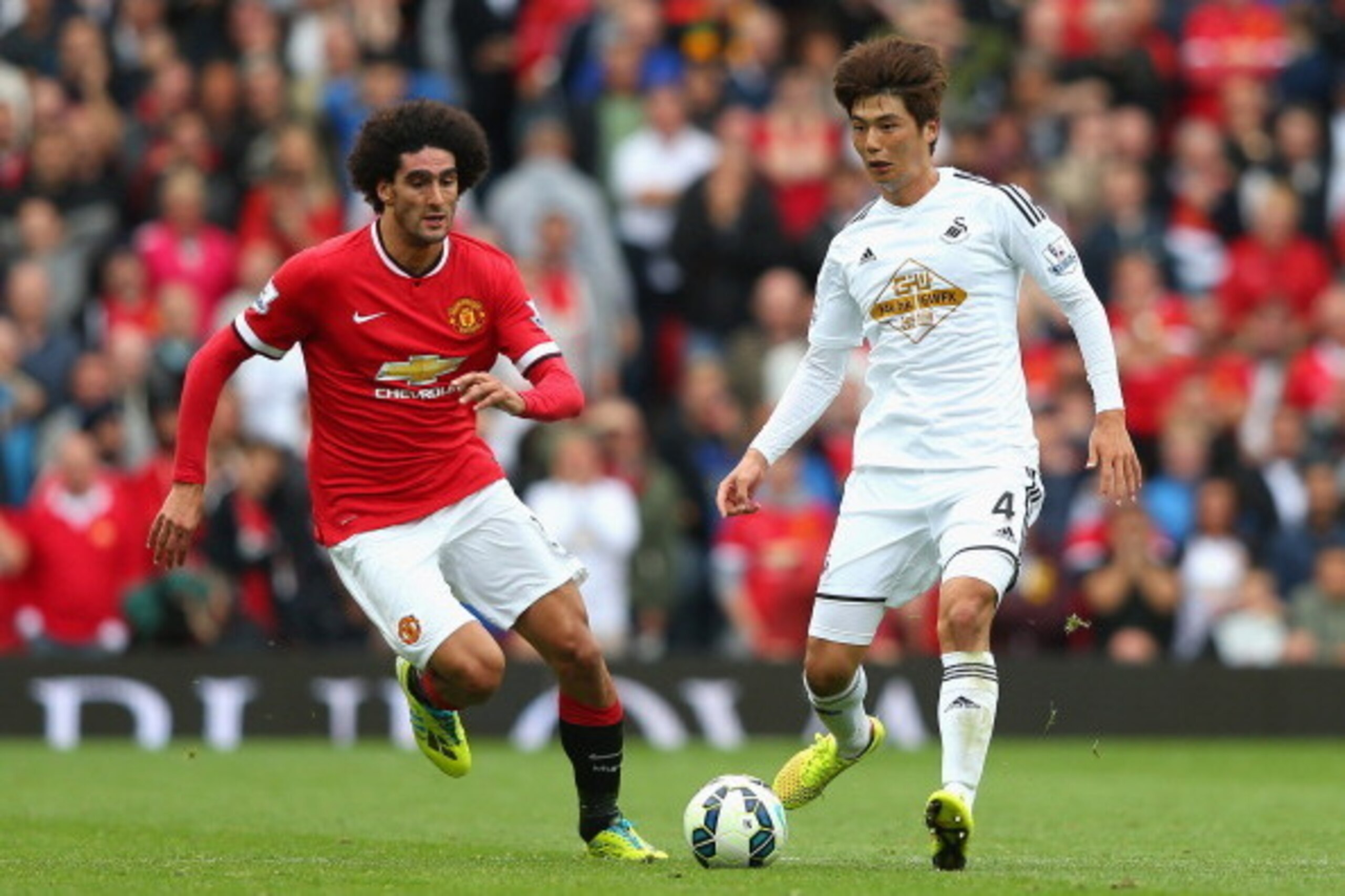 MANCHESTER, ENGLAND - AUGUST 16:  Marouane Fellaini of Manchester United competes with Ki Sung-Yeung of Swansea City during the Barclays Premier League match between Manchester United and Swansea City at Old Trafford on August 16, 2014 in Manchester, Engl