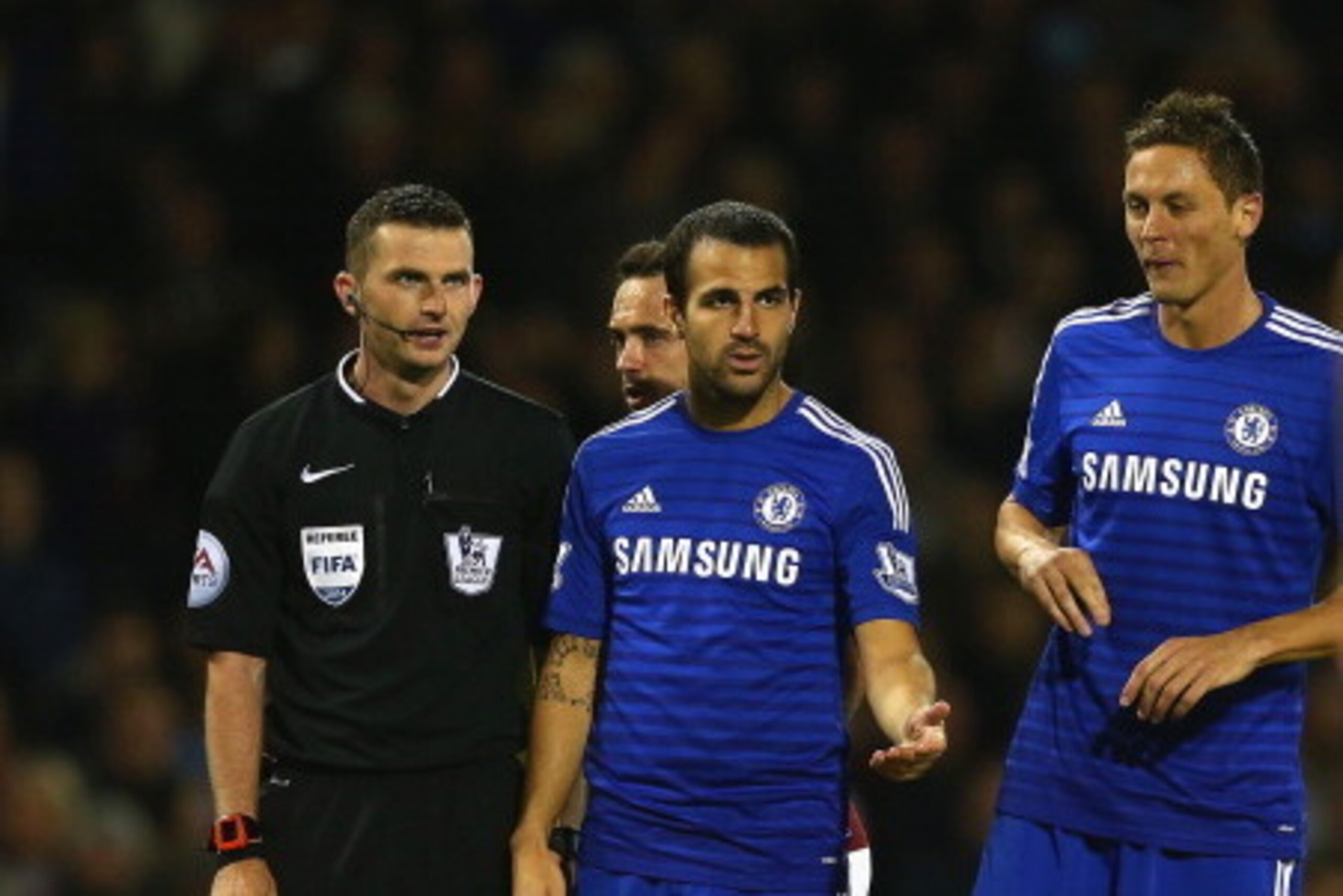 BURNLEY, ENGLAND - AUGUST 18:   Referee Michael Oliver speaks to Cesc Fabregas and Nemanja Matic of Chelsea during the Barclays Premier League match between Burnley and Chelsea at Turf Moor on August 18, 2014 in Burnley, England.  (Photo by Clive Brunskil