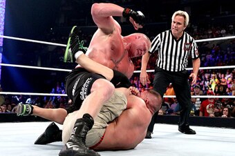 Brock Lesnar beats on John Cena.