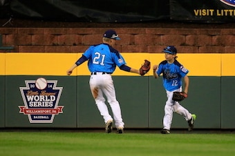 SOUTH WILLIAMSPORT, PA - AUGUST 20:  Austin Kryszczuk #21 celebrates with teammate Alex Barker#12 of Nevada after Barker caught the thrid out of the first inning against Pennsylvania during the United States division game at the Little League World Series