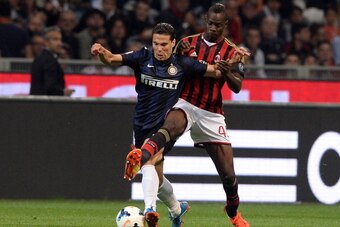 MILAN, ITALY - MAY 04:  Hernanes of FC Inter Milan and Mario Balotelli of AC Milan (R) compete for the ball during the Serie A match between AC Milan and FC Internazionale Milano at Stadio Giuseppe Meazza on May 4, 2014 in Milan, Italy.  (Photo by Claudio