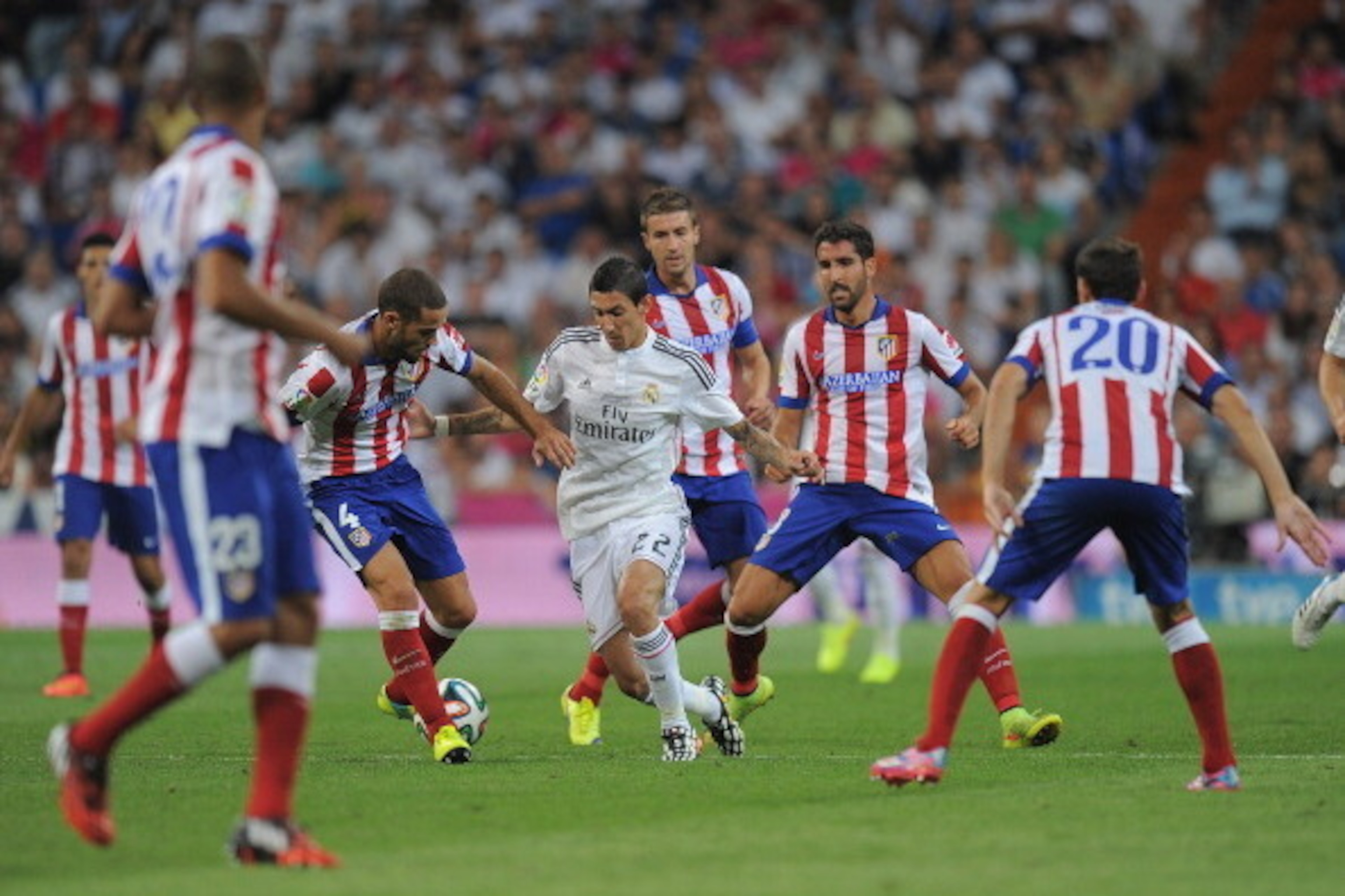 MADRID, SPAIN - AUGUST 19:  Angel di Maria of Real Madrid is surrounded by Club Atletico de Madrid players during the Supercopa first leg match between Real Madrid and Club Atletico de Madrid     at Estadio Santiago Bernabeu on August 19, 2014 in Madrid, 