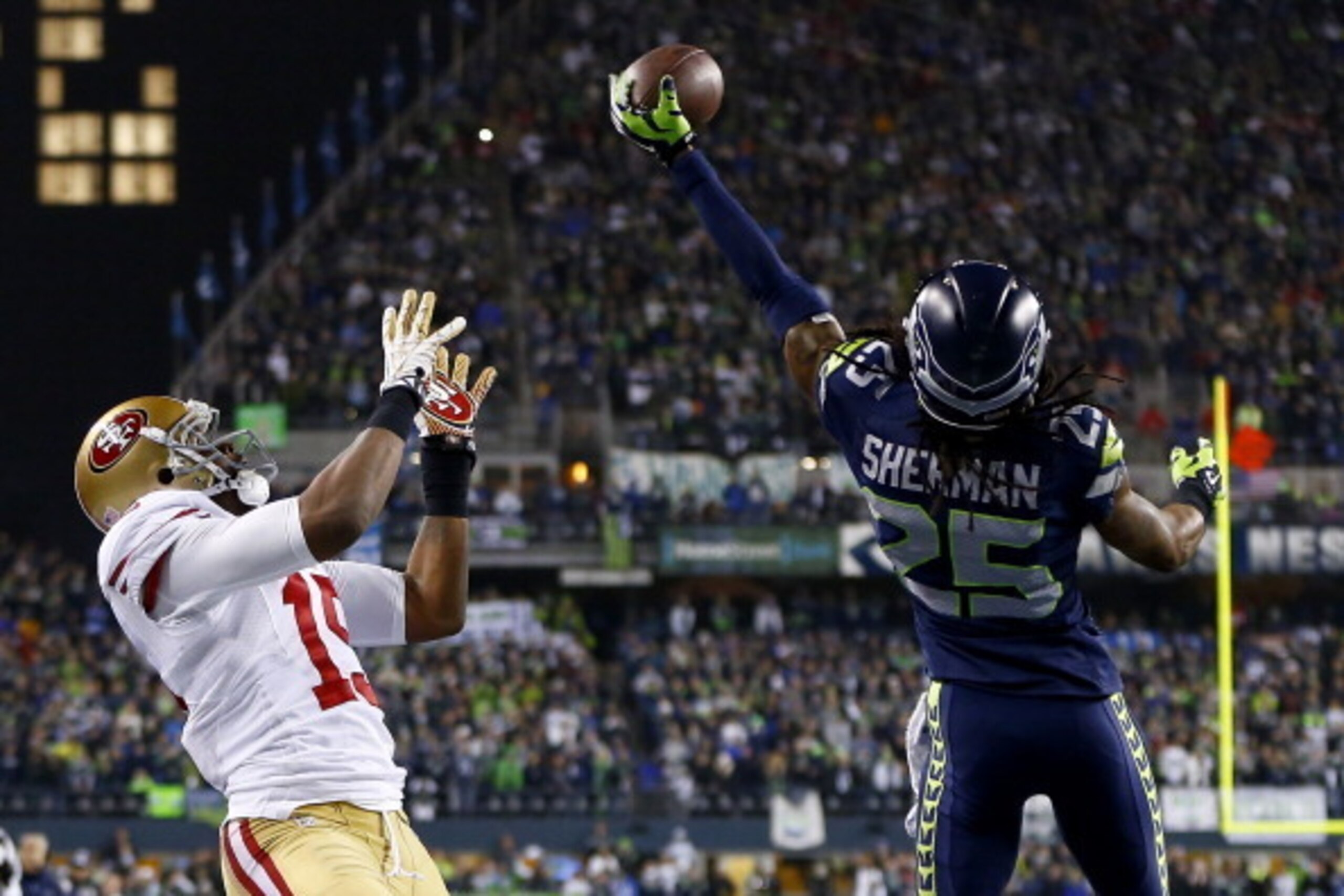 SEATTLE, WA - JANUARY 19:  Cornerback Richard Sherman #25 of the Seattle Seahawks tips the ball up in the air as outside linebacker Malcolm Smith #53 catches it to clinch the victory for the Seahawks against the San Francisco 49ers during the 2014 NFC Cha