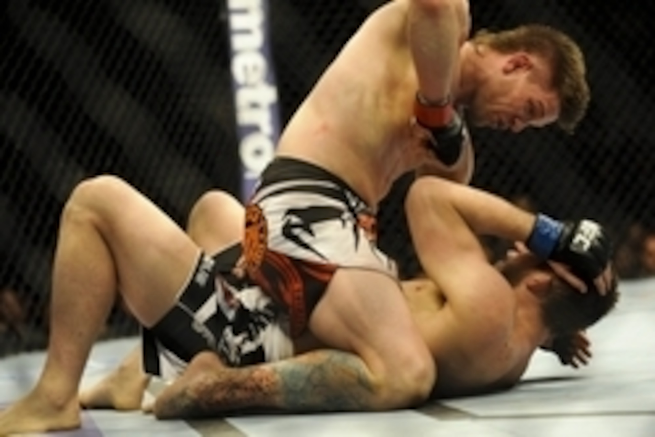 Feb 22, 2014; Las Vegas, NV, USA;  Mike Pyle (red gloves) pins TJ Waldburger (blue gloves) to the mat and throws an elbow to his face during their UFC welterweight bout at Mandalay Bay. Pyle won the bout by way of TKO in the third round. Mandatory Credit: