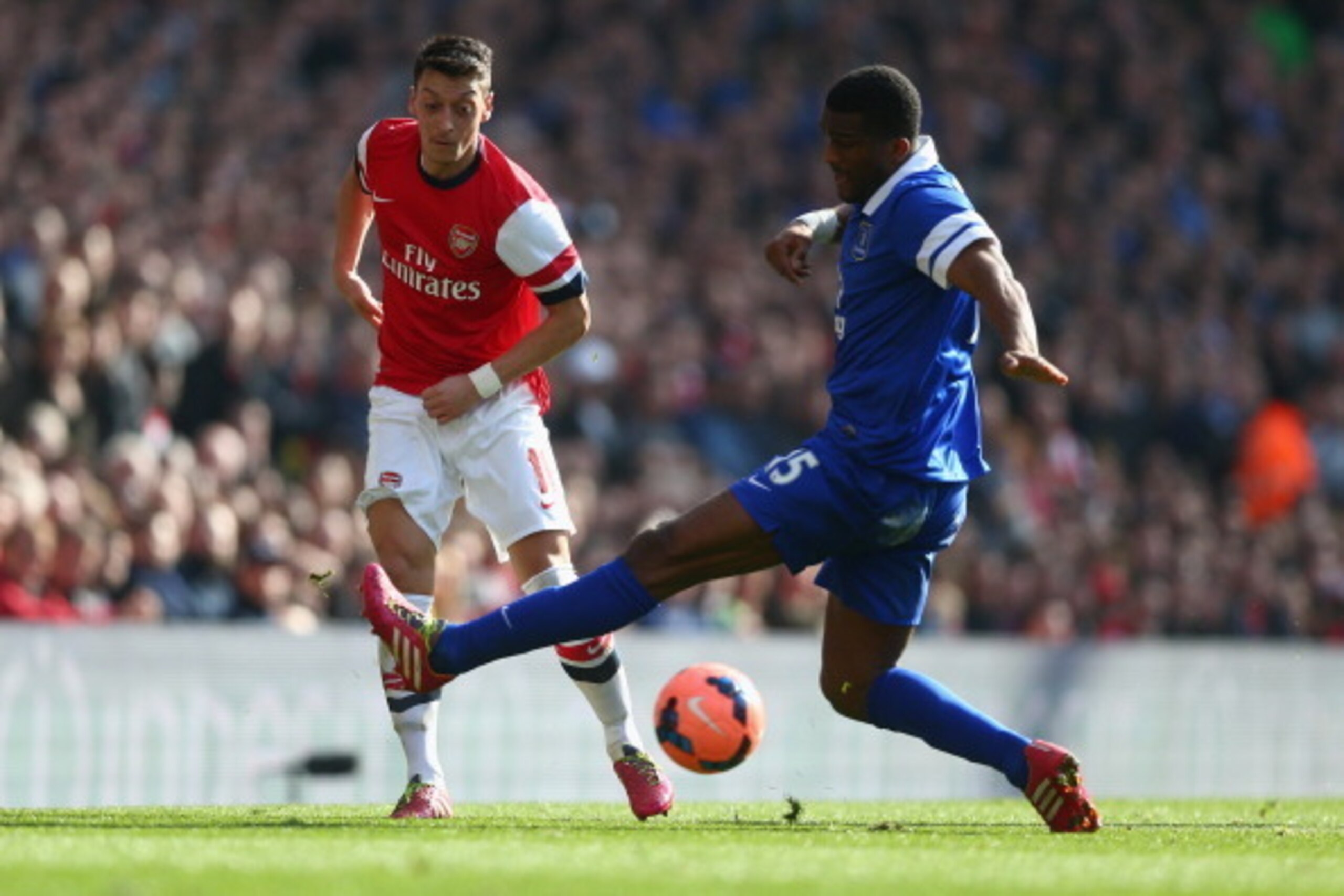 LONDON, ENGLAND - MARCH 08:  Mesut Oezil of Arsenal battles for the ball with Sylvain Distin of Everton during the FA Cup Quarter-Final match between Arsenal and Everton at Emirates Stadium on March 8, 2014 in London, England.  (Photo by Paul Gilham/Getty