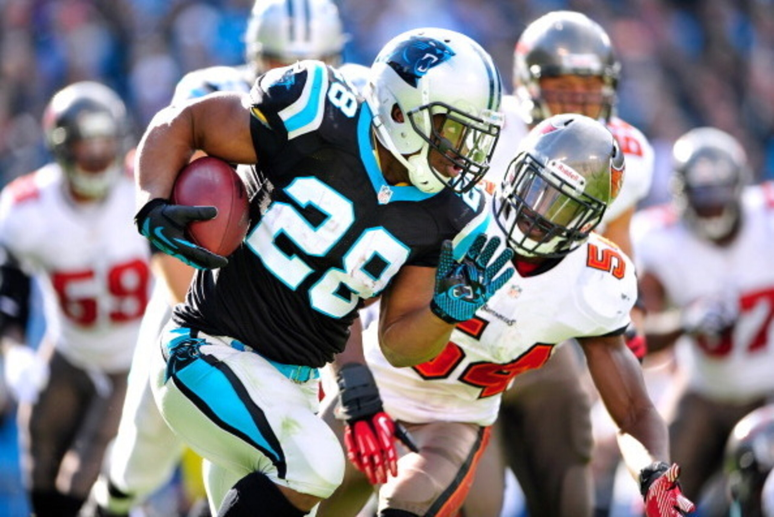CHARLOTTE, NC - DECEMBER 01:  Lavonte David #54 of the Tampa Bay Buccaneers pursues Jonathan Stewart #28 of the Carolina Panthers during play at Bank of America Stadium on December 1, 2013 in Charlotte, North Carolina.  (Photo by Grant Halverson/Getty Ima