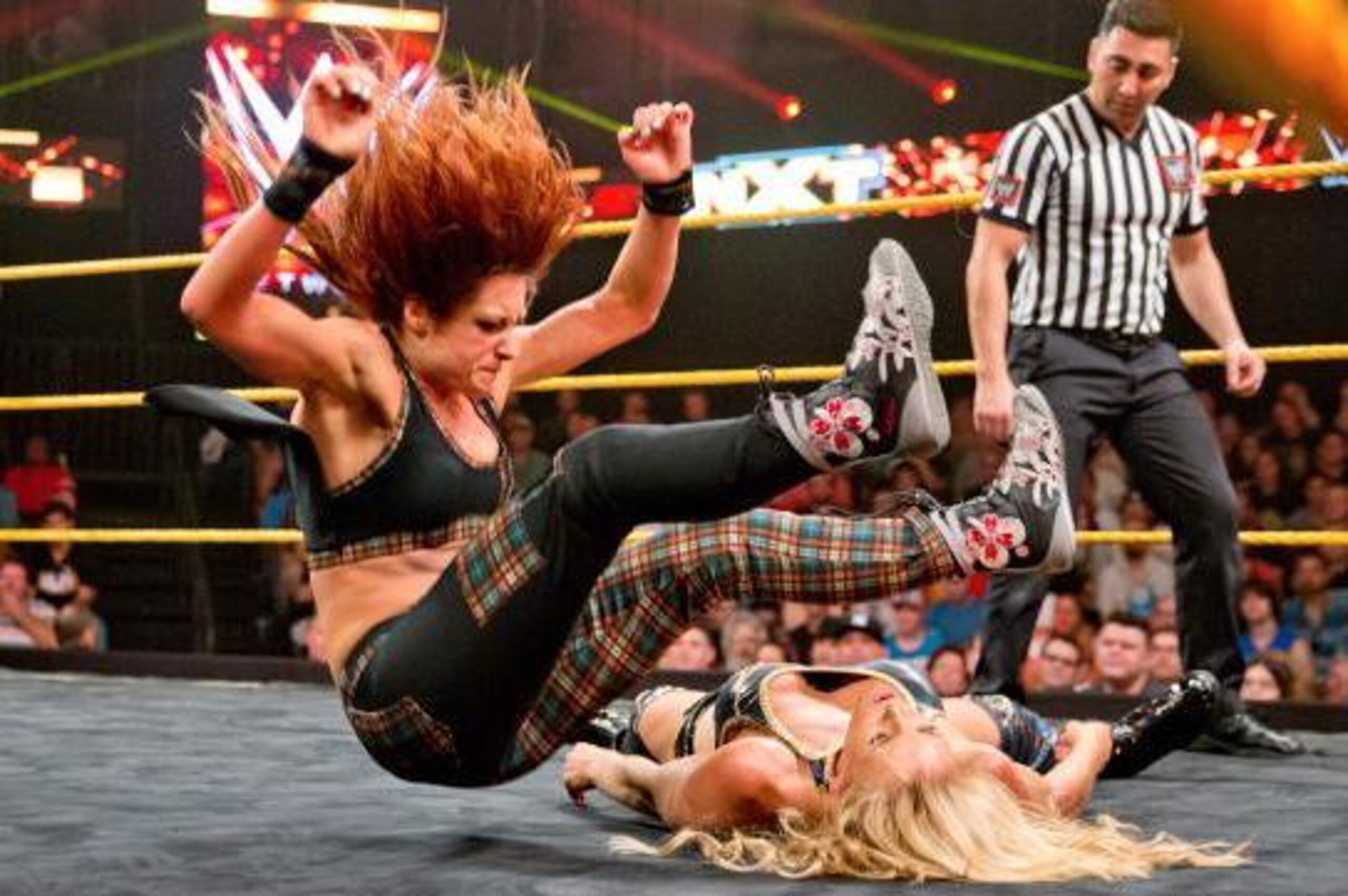 Becky Lynch nails Charlotte with a leg drop.