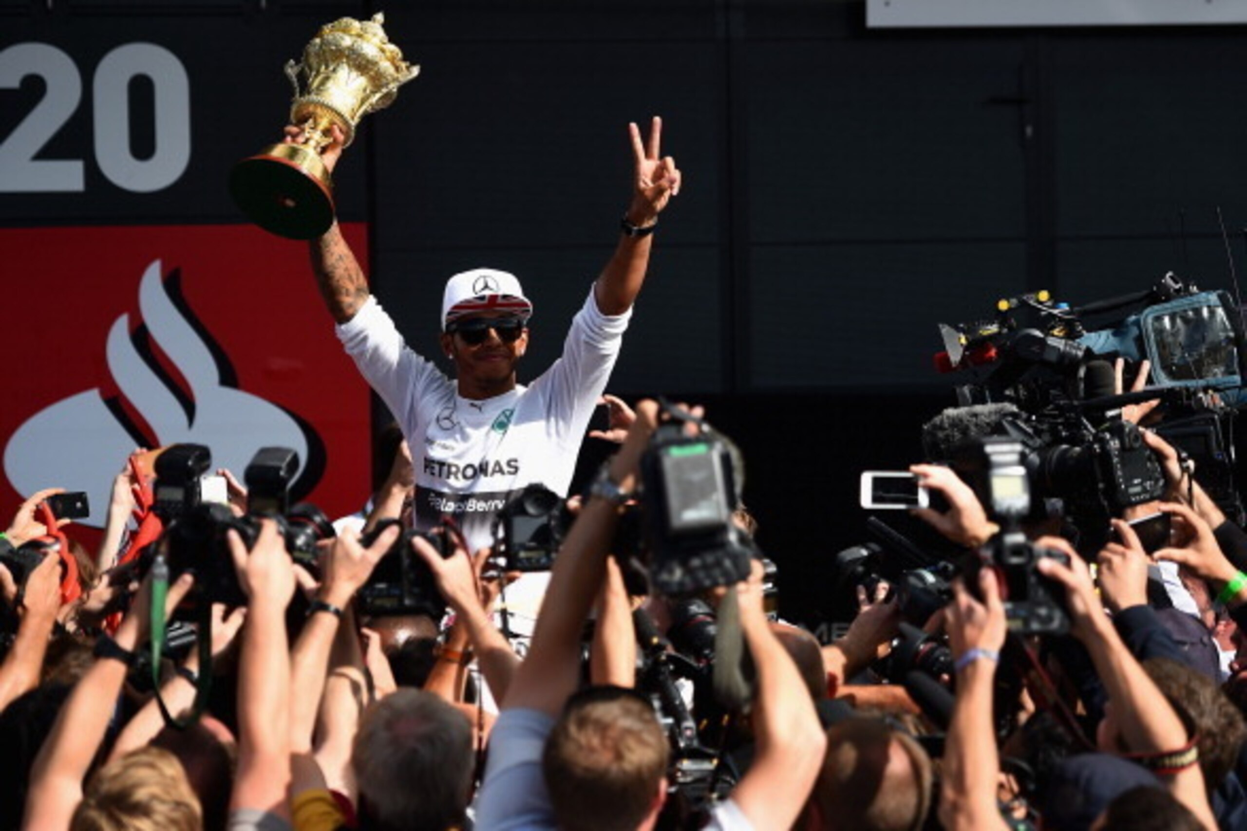NORTHAMPTON, ENGLAND - JULY 06:  Lewis Hamilton of Great Britain and Mercedes GP his held aloft by his team mates as he holds the old British Grand Prix Trophy while he celebrates winning the British Formula One Grand Prix at Silverstone Circuit on July 6