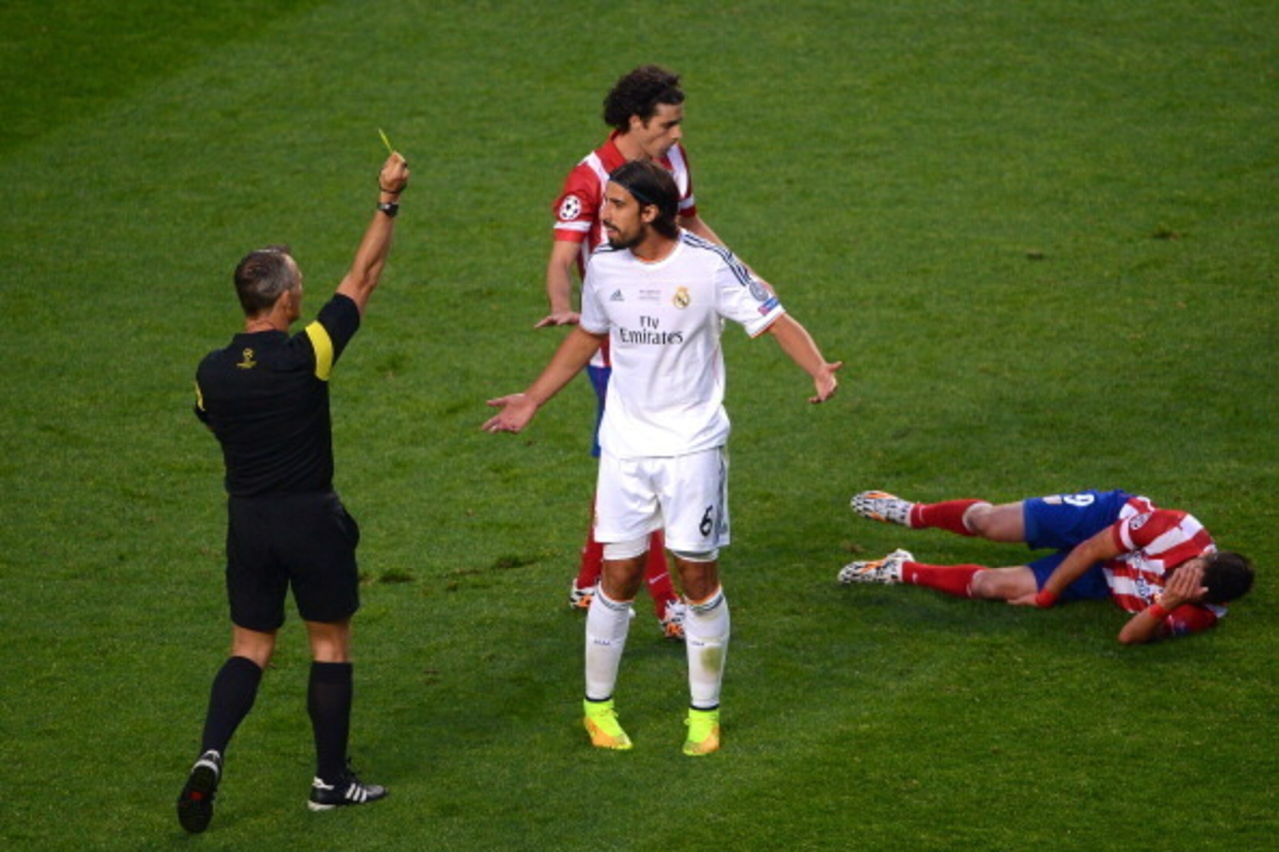 LISBON, PORTUGAL - MAY 24:  Referee Bjorn Kuipers shows Sami Khedira of Real Madrid a yellow card after clashing with David Villa of Club Atletico de Madrid during the UEFA Champions League Final between Real Madrid and Atletico de Madrid at Estadio da Lu
