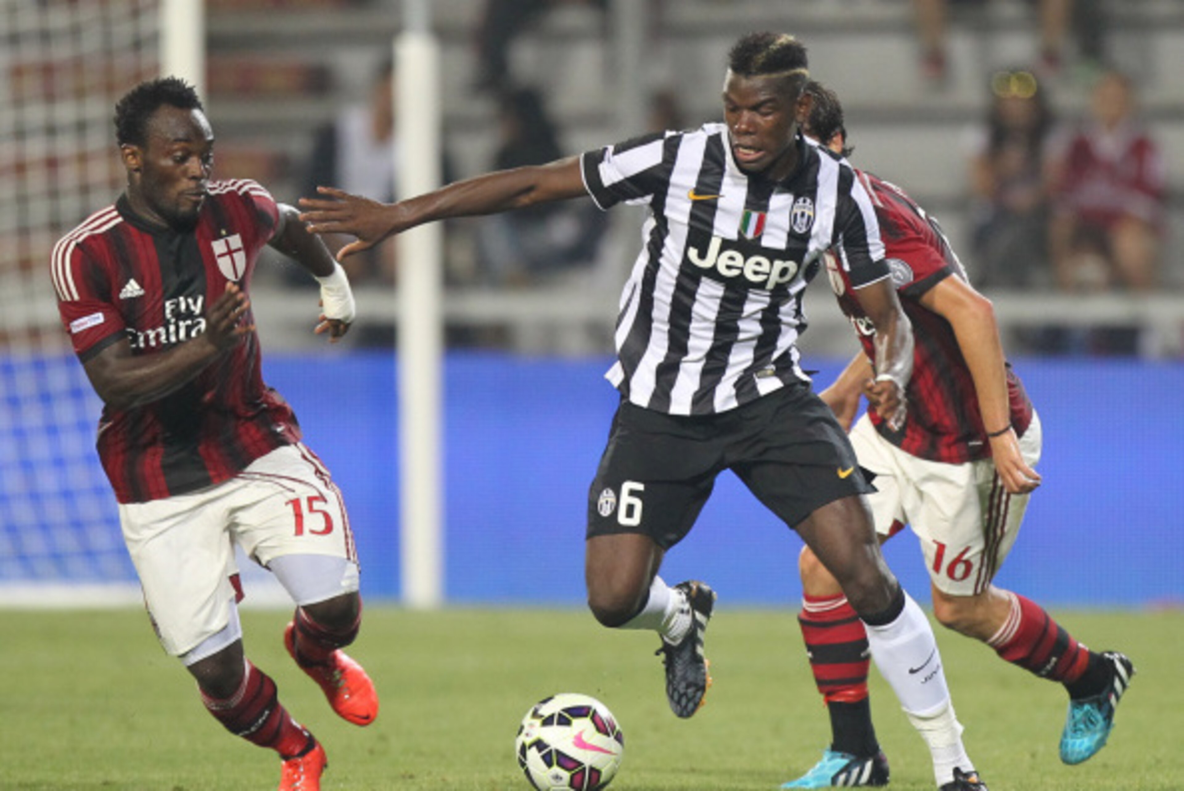 REGGIO NELL'EMILIA, ITALY - AUGUST 23: Paul Pogba (C) of FC Juventus competes for the ball with Michael Essien of AC Milan during the TIM Preseason Tournament between US Sassuolo, FC Juventus and AC Milan at Mapei Stadium - Citta' del Tricolore on August 