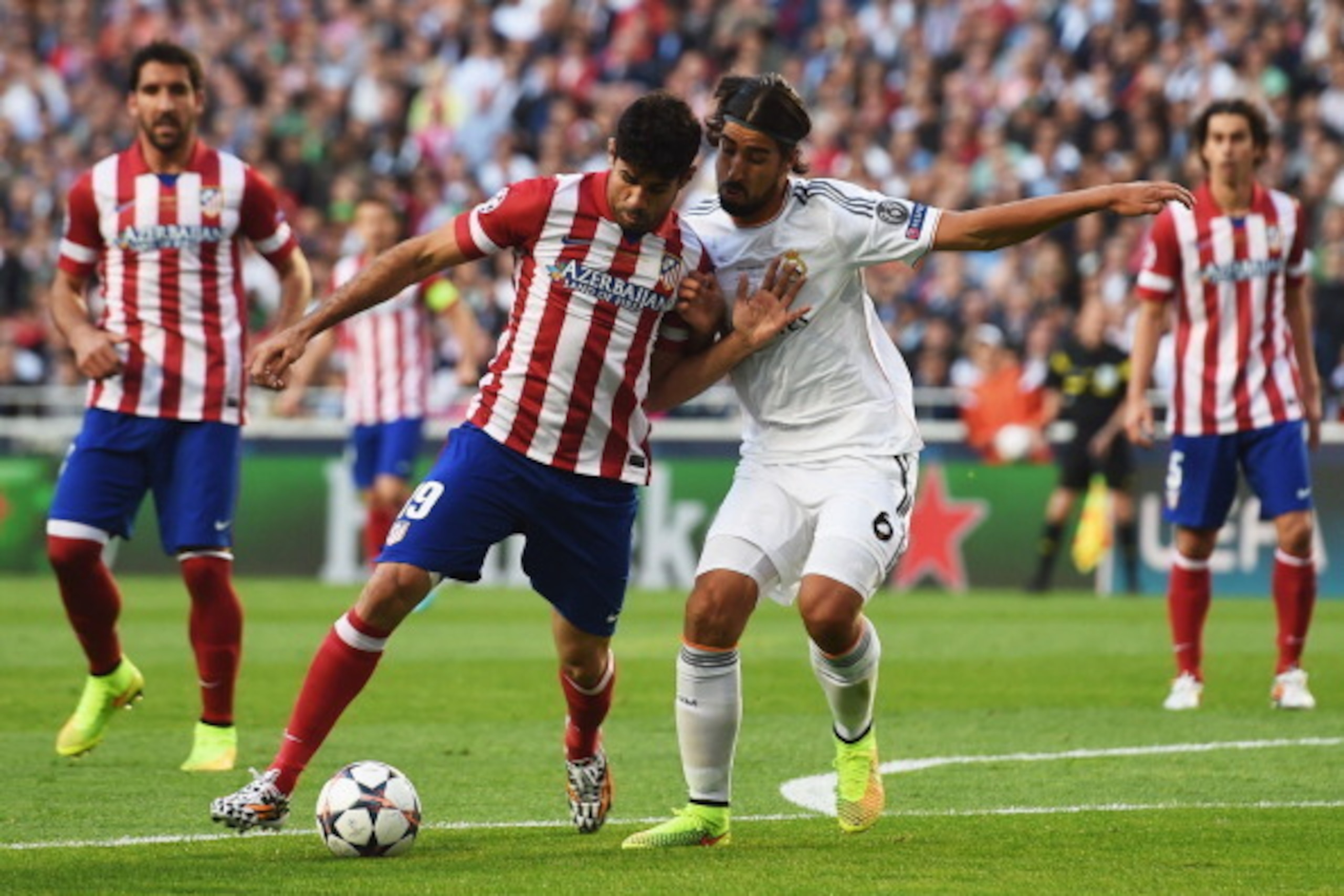 LISBON, PORTUGAL - MAY 24:  Diego Costa of Club Atletico de Madrid holds off Sami Khedira of Real Madrid during the UEFA Champions League Final between Real Madrid and Atletico de Madrid at Estadio da Luz on May 24, 2014 in Lisbon, Portugal.  (Photo by Sh