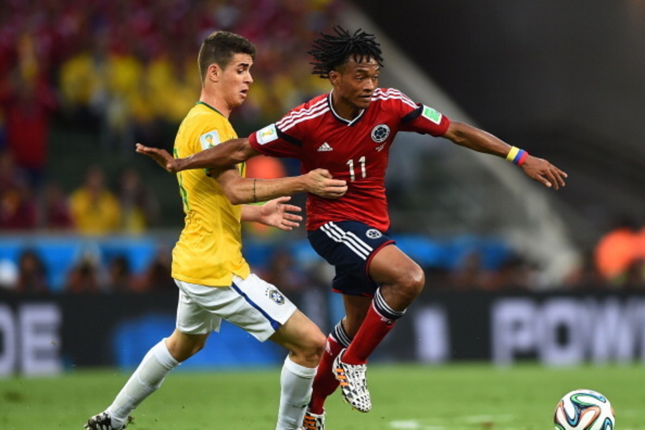FORTALEZA, BRAZIL - JULY 04: Oscar of Brazil challenges Juan Guillermo Cuadrado of Colombia during the 2014 FIFA World Cup Brazil Quarter Final match between Brazil and Colombia at Castelao on July 4, 2014 in Fortaleza, Brazil.  (Photo by Laurence Griffit