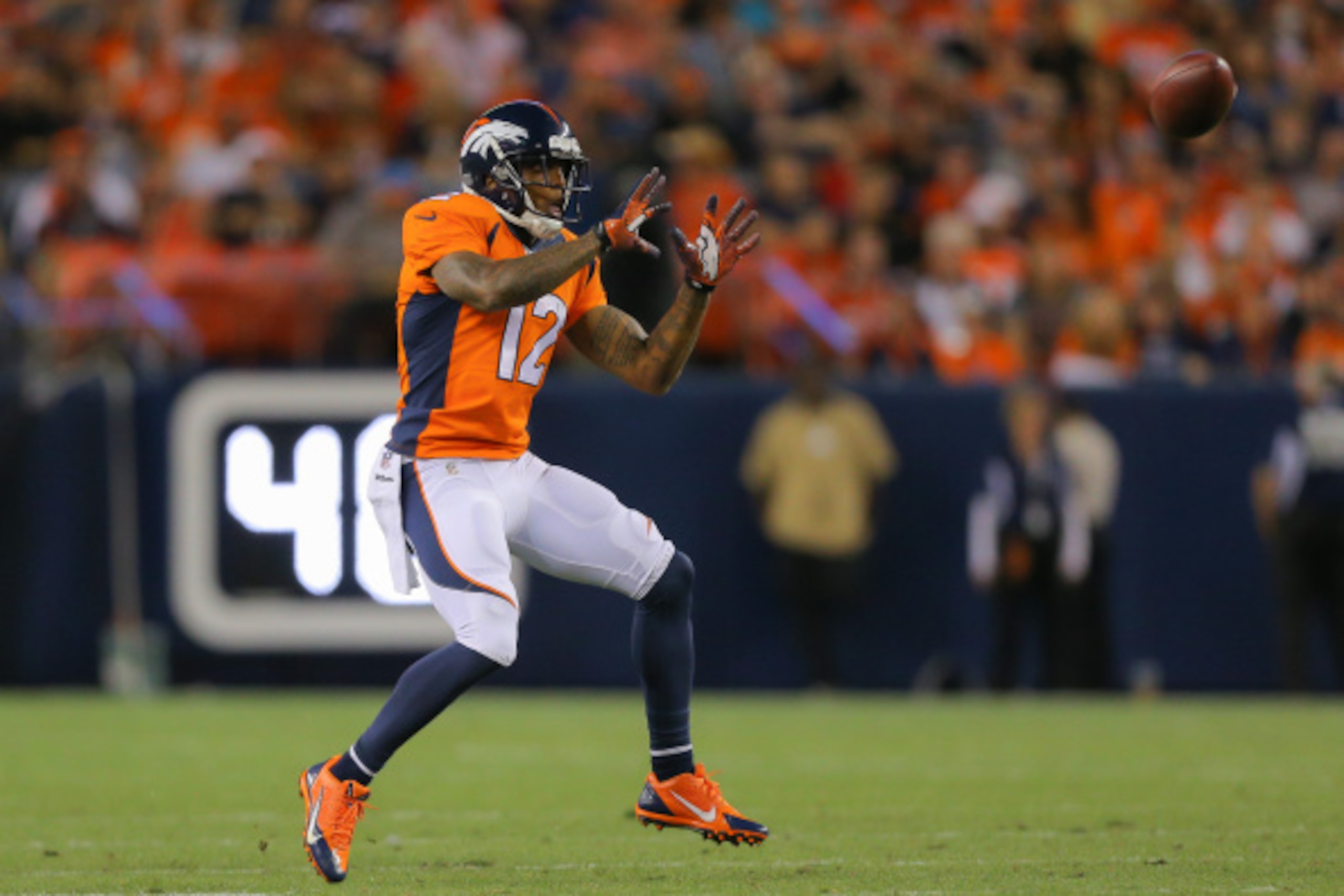 DENVER, CO - AUGUST 23:  Wide receiver Andre Caldwell #12 of the Denver Broncos has a reception for a first down against the Houston Texans during a preseason game at Sports Authority Field at Mile High on August 23, 2014 in Denver, Colorado.  (Photo by J
