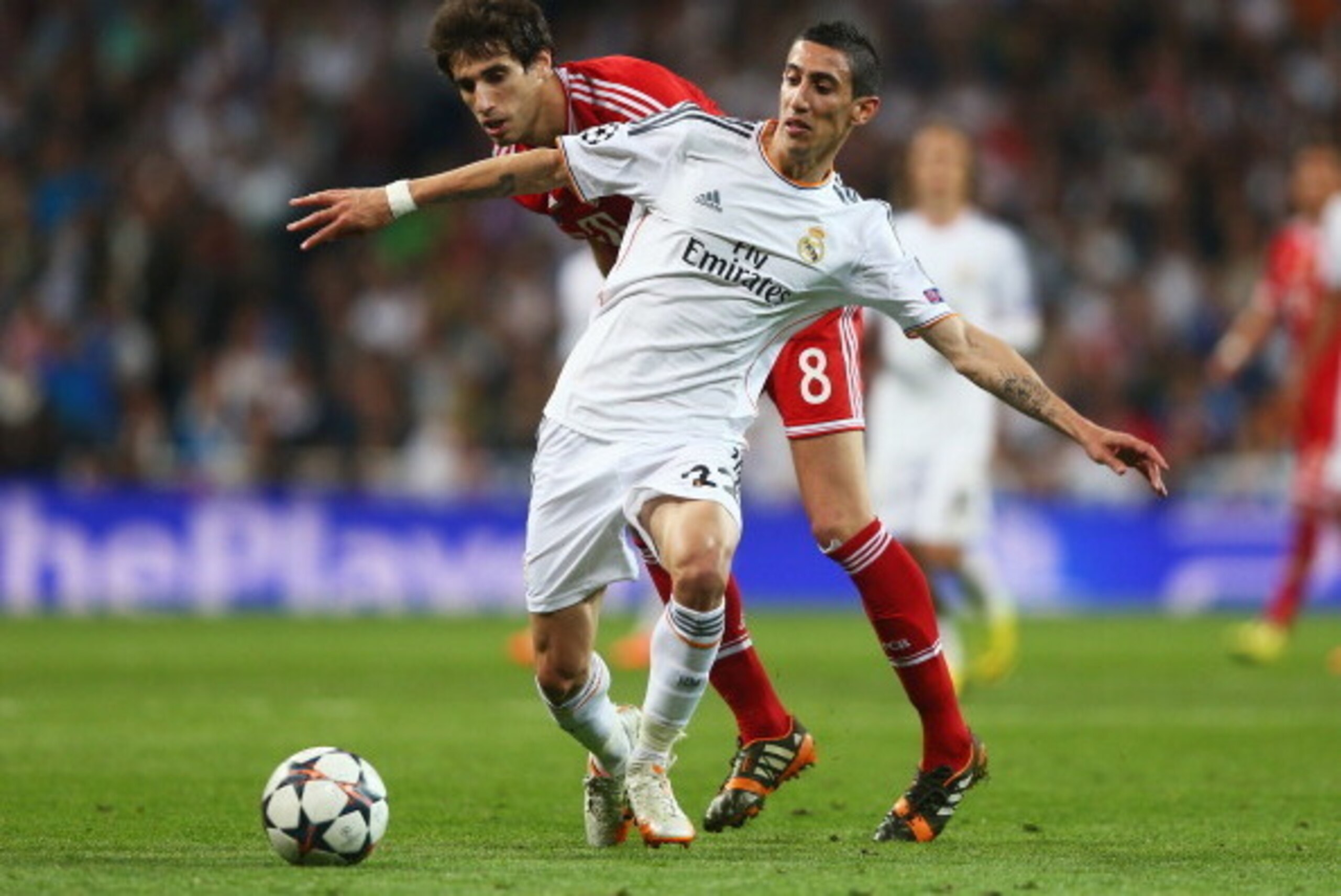 MADRID, SPAIN - APRIL 23: Angel Di Maria of Real Madrid is challenged by Javi Martinez of Bayern Muenchen during the UEFA Champions League semi-final first leg match between Real Madrid and FC Bayern Muenchen at the Estadio Santiago Bernabeu on April 23, 