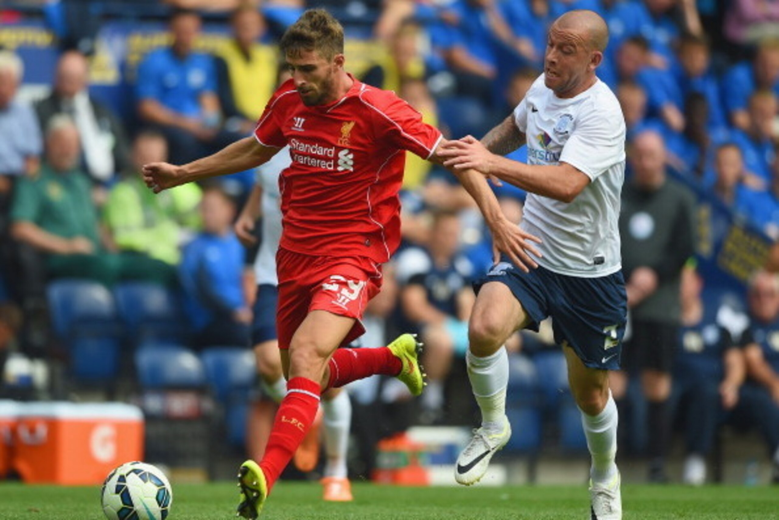 PRESTON, LANCASHIRE - JULY 19:  Keith Keane of Preston in action with Fabio Borini of Liverpool during the pre season friendly match between Preston North End and Liverpool at Deepdale on July 19, 2014 in Preston, Lancashire.  (Photo by Michael Regan/Gett