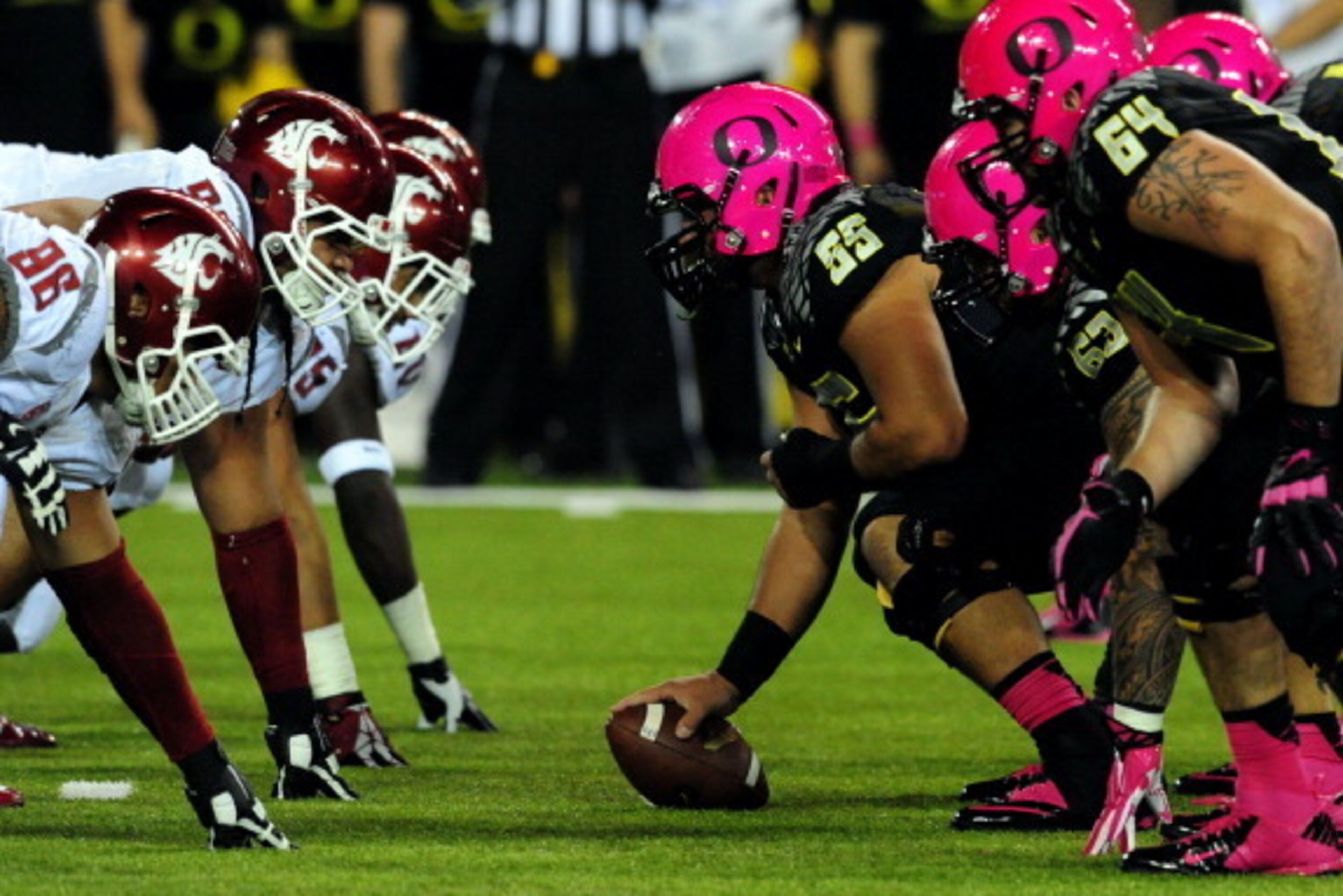 EUGENE, OR - OCTOBER 19: Wearing pink helmets, offensive linesman Hroniss Grasu #55 of the Oregon Ducks and the offensive line get set at the line of scrimmage in the first quarter of the game against the Washington State Cougars at Autzen Stadium on Octo
